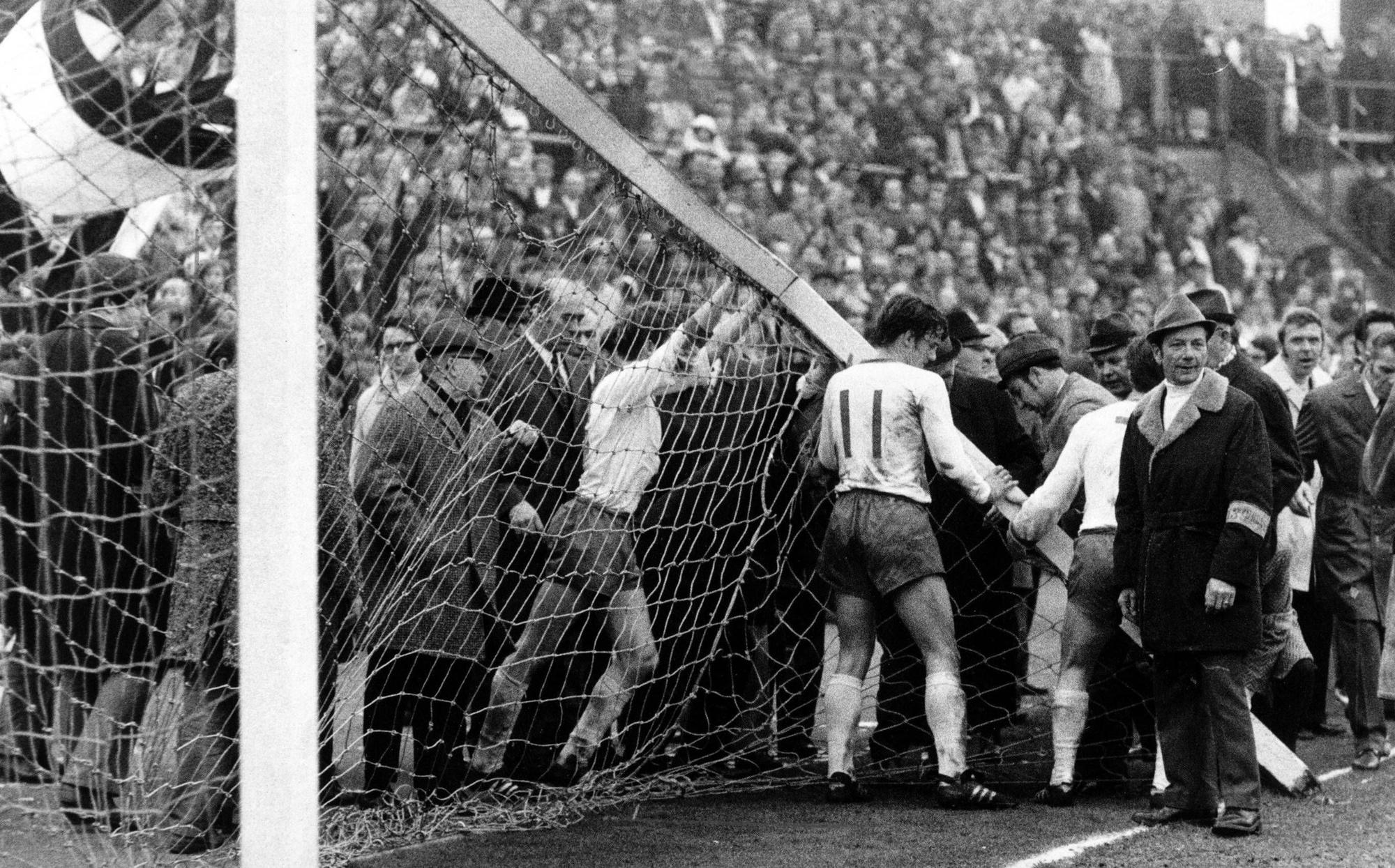 Am 3. April 1971 bricht bei der Bundesliga-Partie zwischen Borussia Mönchengladbach und dem SV Werder Bremen auf dem Gladbacher Bökelberg der Torpfosten. Auf diesem Foto versuchen Bremer Spieler, dass Tor wieder aufzurichten. Sie drücken und schieben.