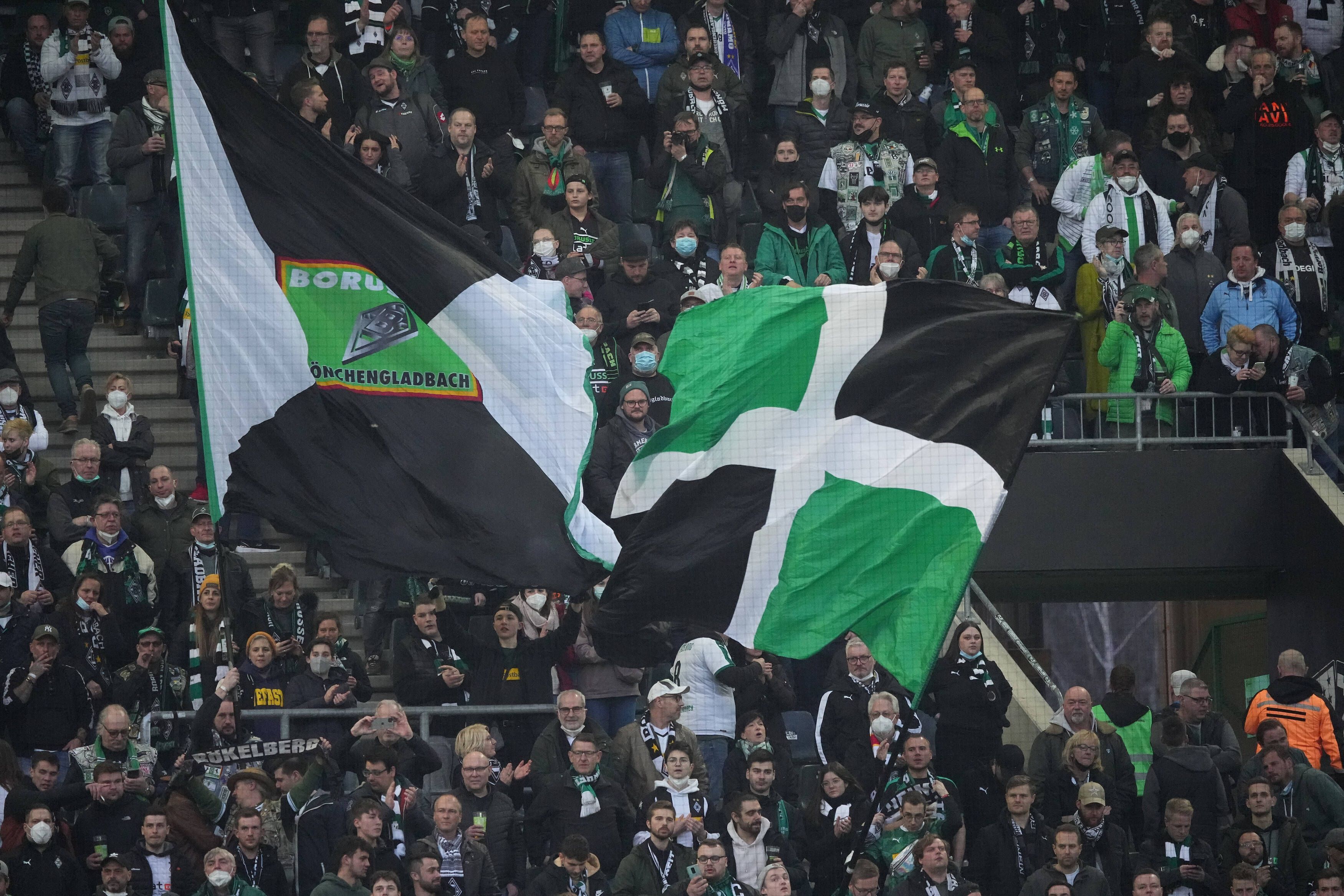 Fans von Borussia Mönchengladbach am 12. März 2022 im Borussia-Park. Fahnen werden geschwenkt.