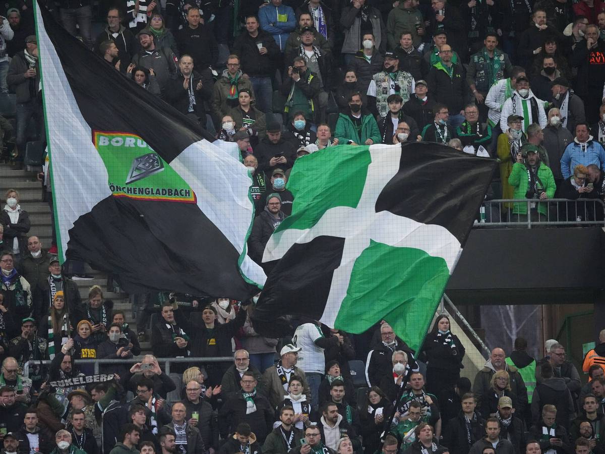 Fans von Borussia Mönchengladbach am 12. März 2022 im Borussia-Park. Fahnen werden geschwenkt.
