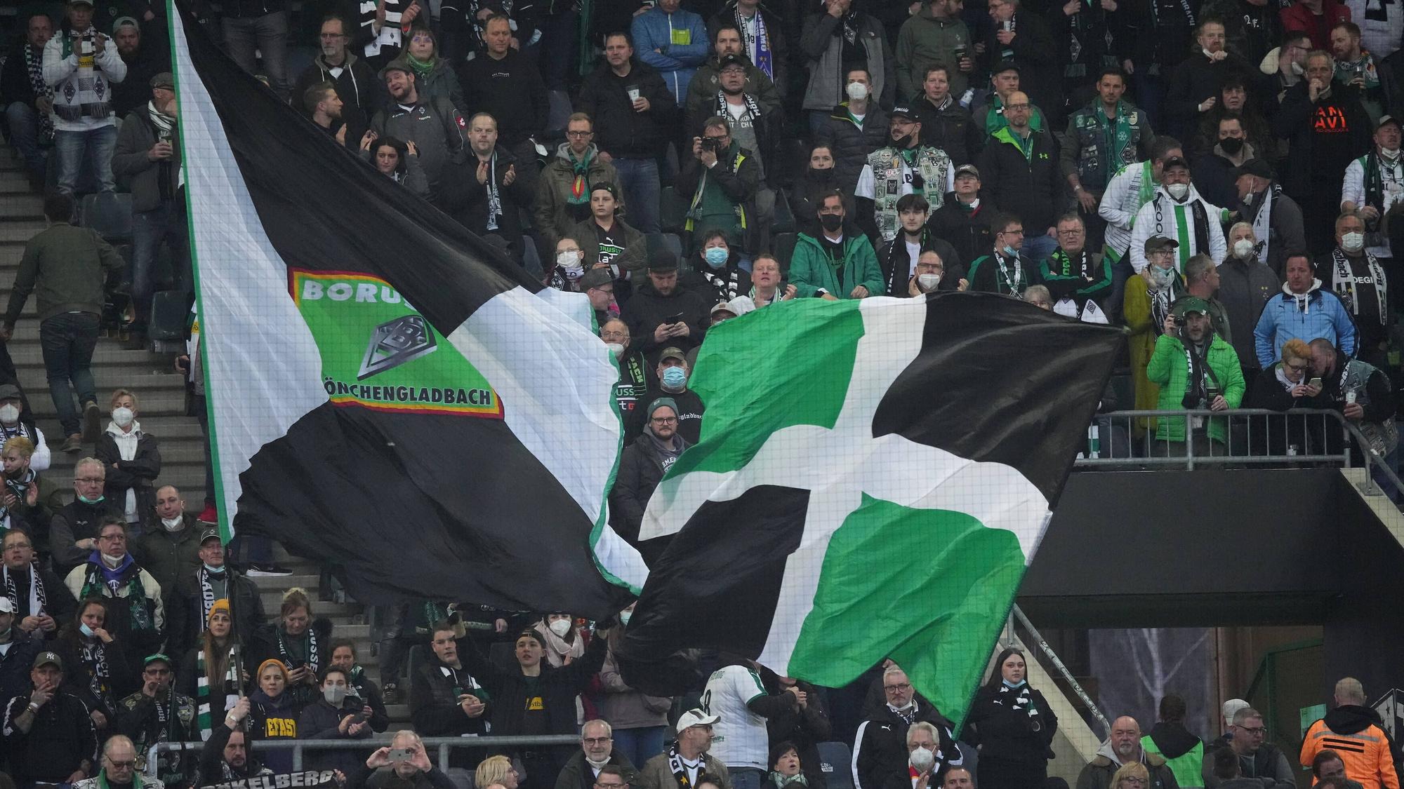 Fans von Borussia Mönchengladbach am 12. März 2022 im Borussia-Park. Fahnen werden geschwenkt.