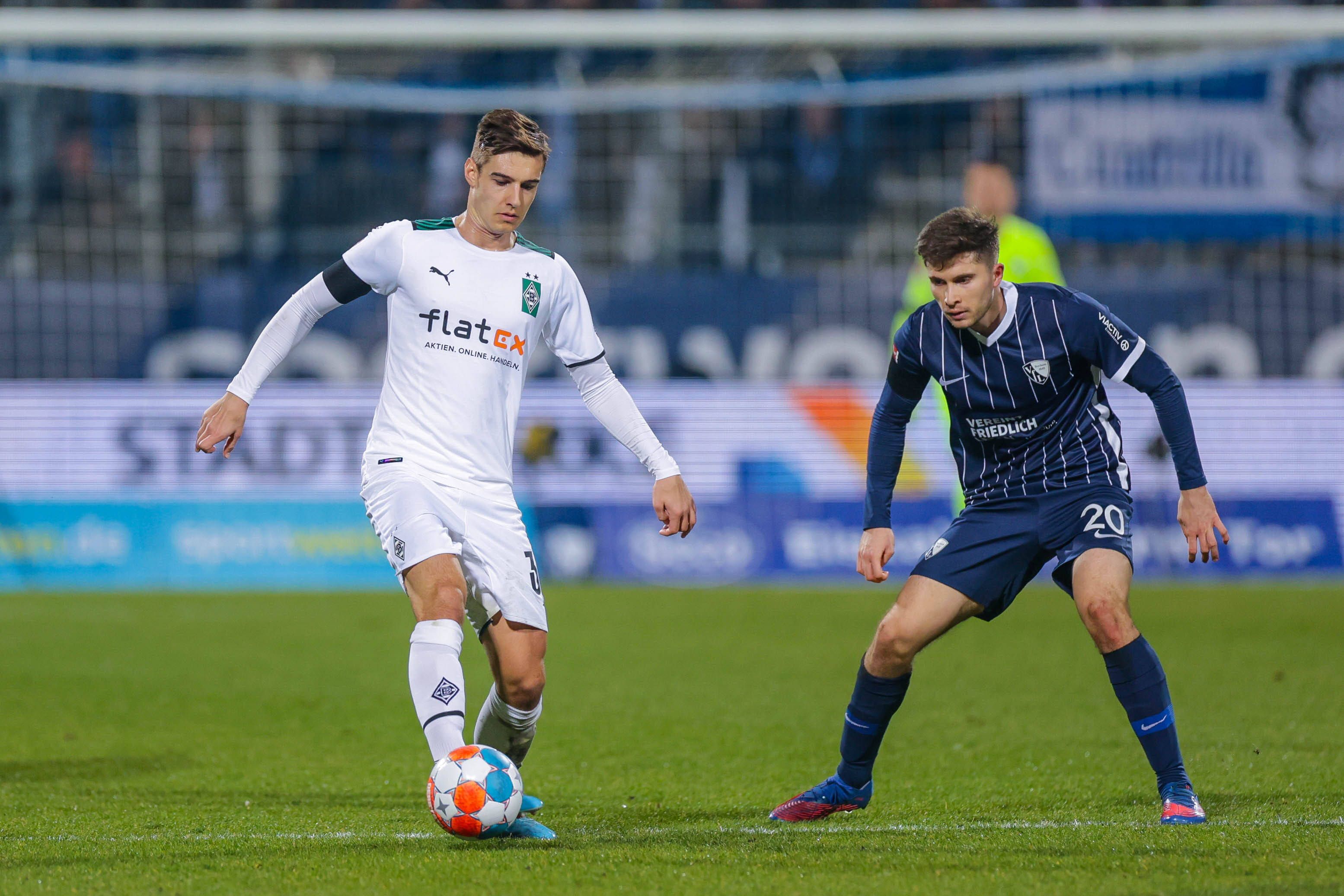 Florian Neuhaus (l.) von Borussia Mönchengladbach im Bundesliga-Duell (18. März 2022) mit Elvis Rexhbecaj (r.) vom VfL Bochum. Neuhaus hat den Ball am Fuß.
