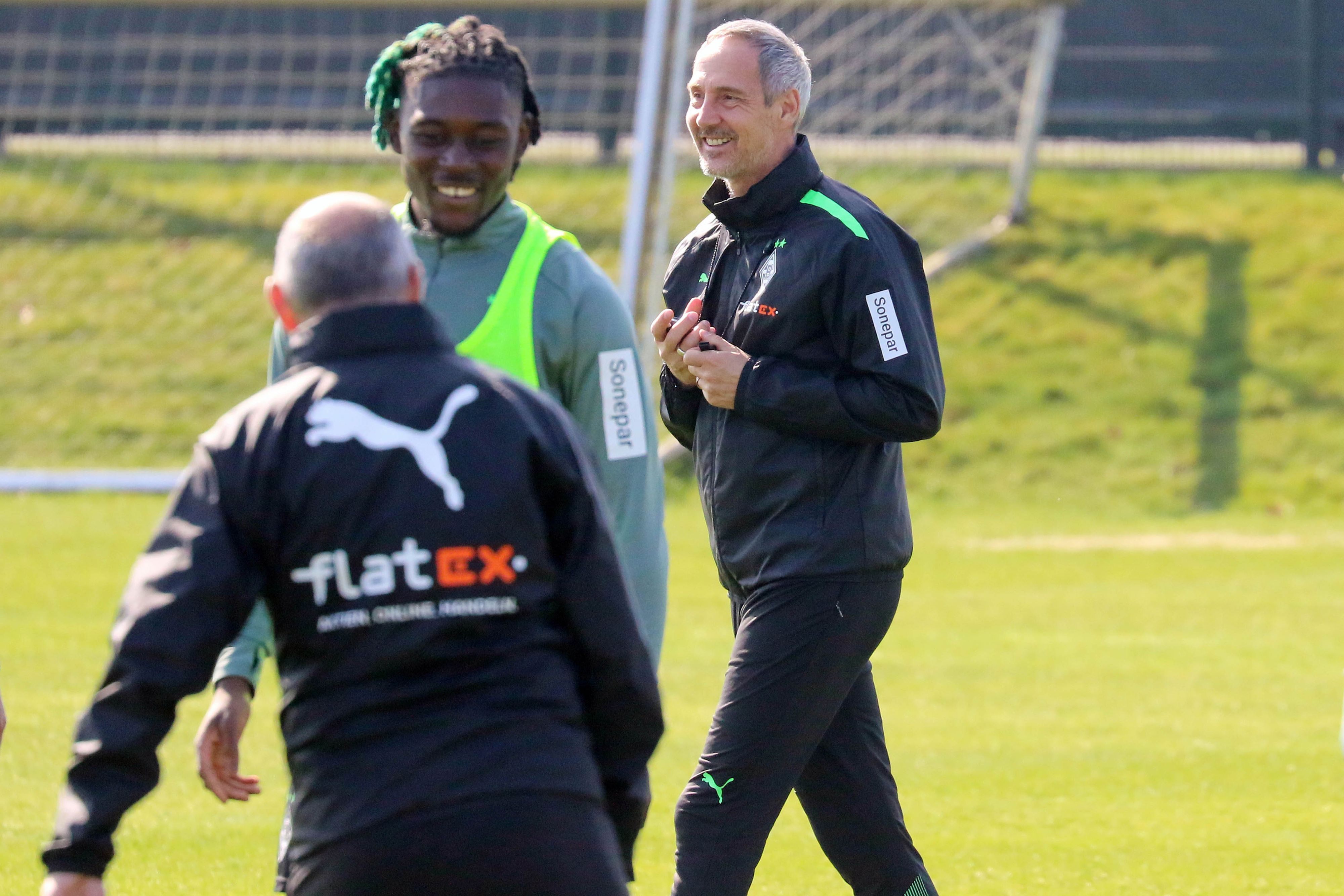 Gute Stimmung im Borussia-Park. Cheftrainer Adi Hütter ist nach überstandener Corona-Infektion wieder auf dem Trainingsplatz. Adi Hütter (r.) lächelt. Manu Kone (l.) lächelt ebenfalls in Richtung der Kamera.