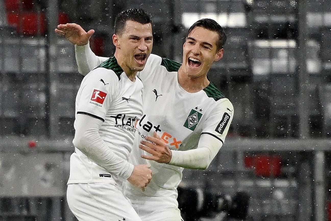 Borussia-Mönchengladbach-Verteidiger Stefan Lainer (l.) bejubelt gemeinsam mit Florian Neuhaus (r.) seinen 2:1 Treffer in der Allianz-Arena gegen den FC Bayern München. Lainer und Neuhaus brüllen ihre Freude heraus.