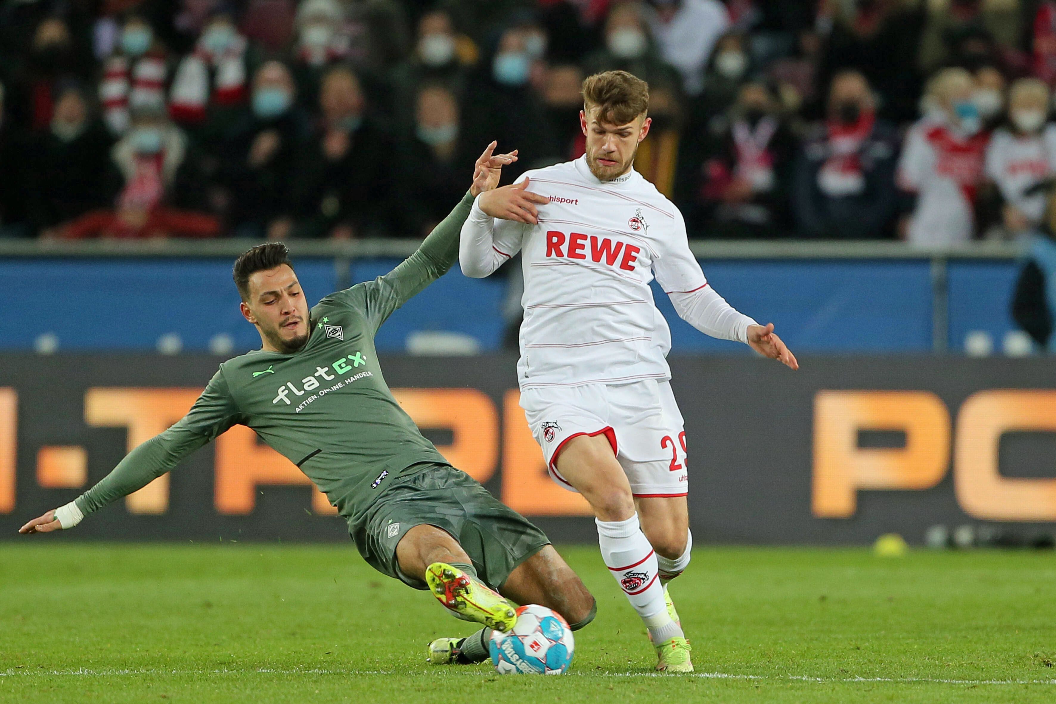 Im Hinspiel (27. November 2021) hat Borussia Mönchengladbach mit 1:4 beim 1. FC Köln verloren. In dieser Szene kämpfen Ramy Bensebaini (l.) und Jan Thielmann (r.) um den Ball. Bensebaini grätscht.