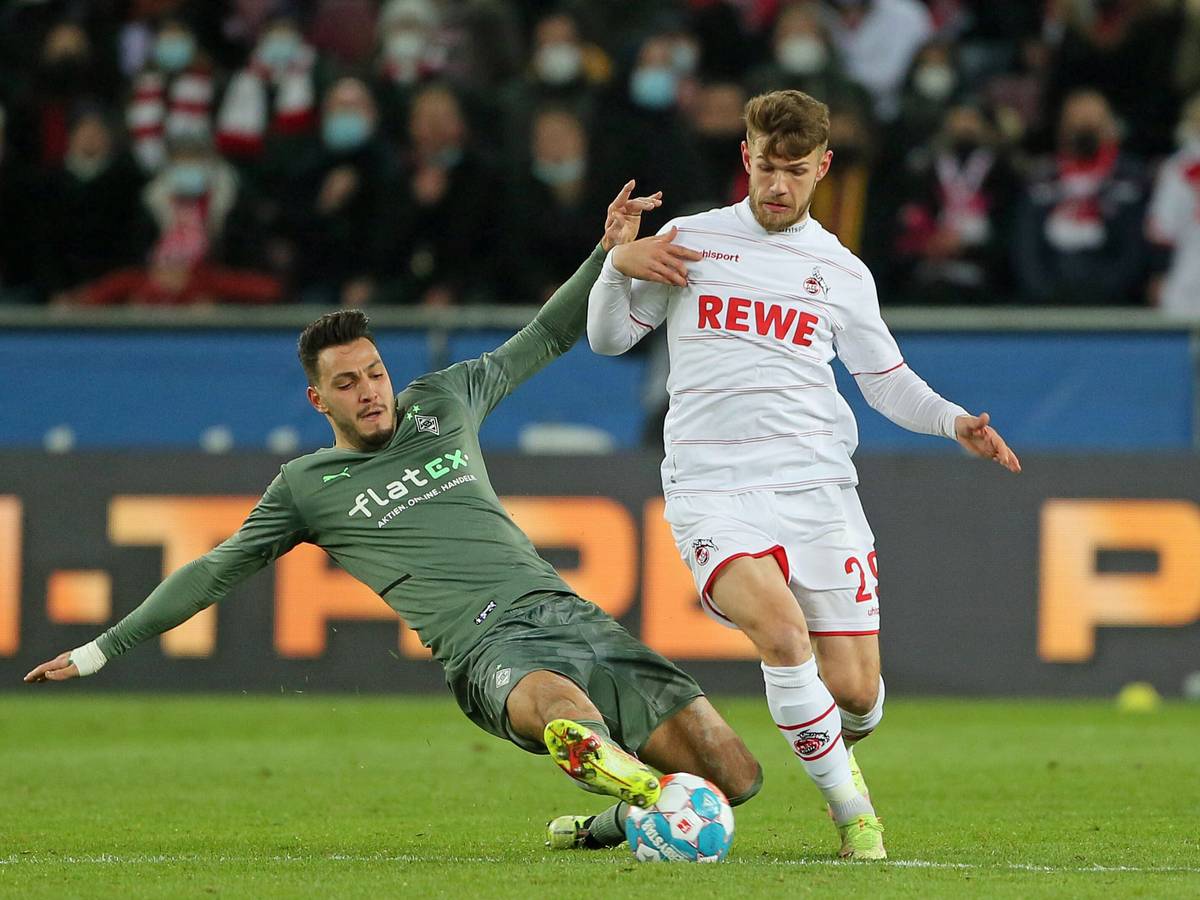 Im Hinspiel (27. November 2021) hat Borussia Mönchengladbach mit 1:4 beim 1. FC Köln verloren. In dieser Szene kämpfen Ramy Bensebaini (l.) und Jan Thielmann (r.) um den Ball. Bensebaini grätscht.