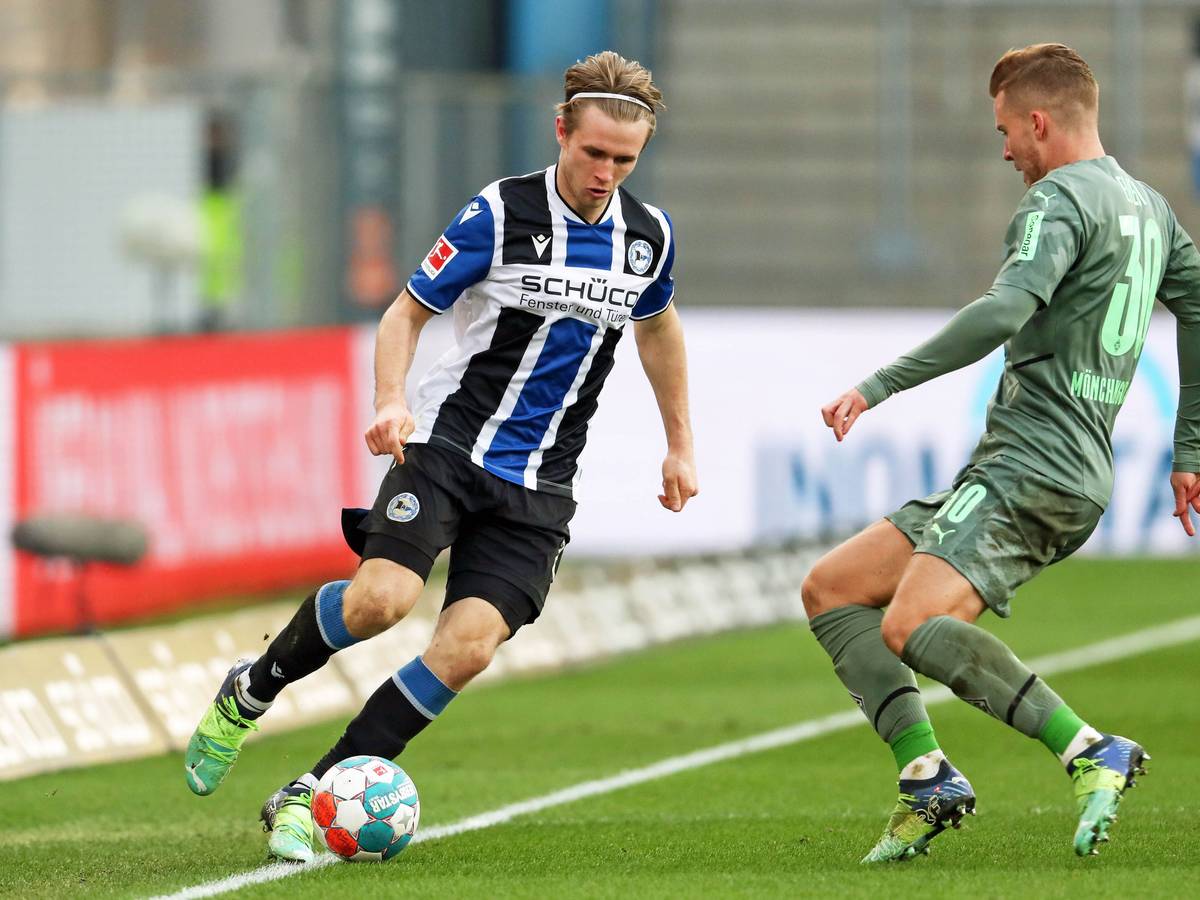 Patrick Wimmer (l.) von Arminia Bielefeld im Zweikampf mit Nico Elvedi (r.) von Borussia Mönchengladbach im Bundesligaspiel am 5. Februar 2022 auf der Alm. Wimmer hat den Ball am Fuß.