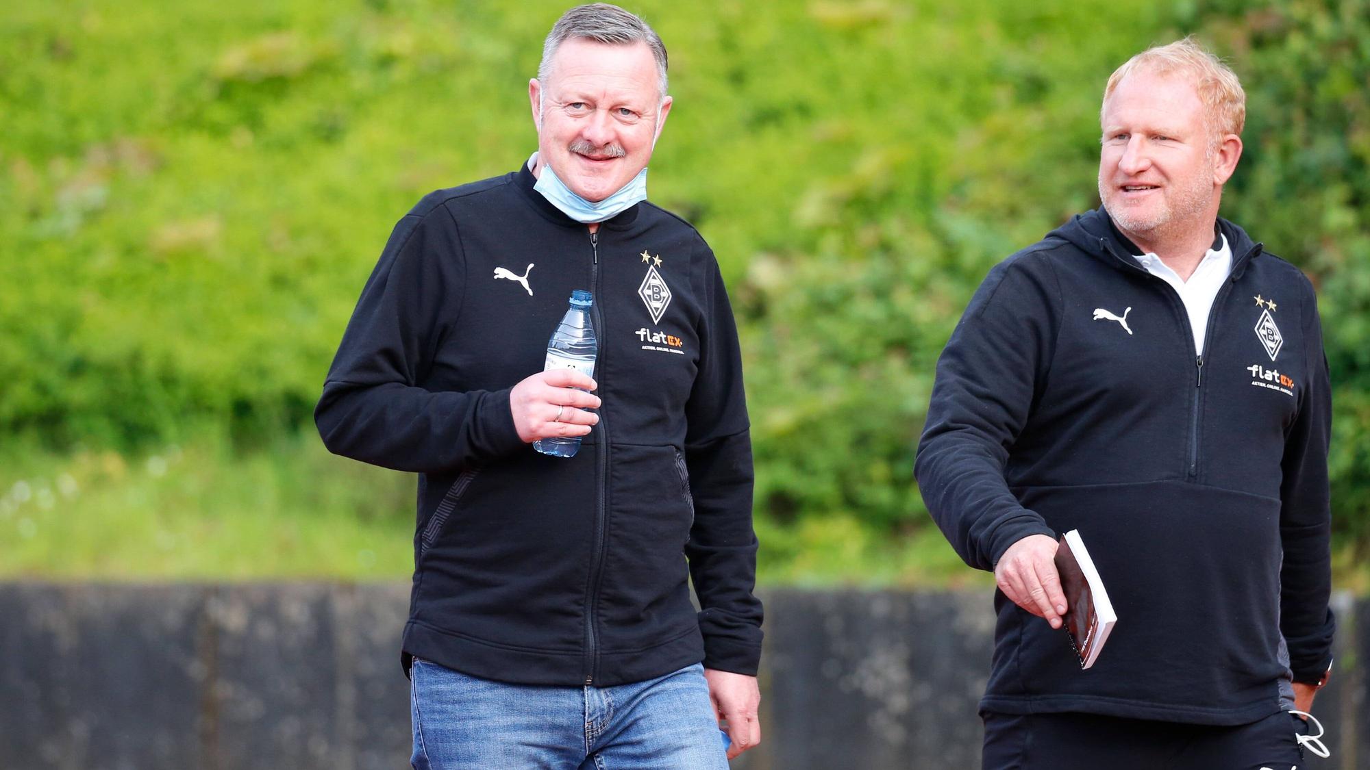 Roland Virkus (l.) und Heiko Vogel (r.) bei einem Spiel der U23 von Borussia Mönchengladbach am 28. Mai 2021 im Rheydter Grenzlandstadion. Beide lächeln.
