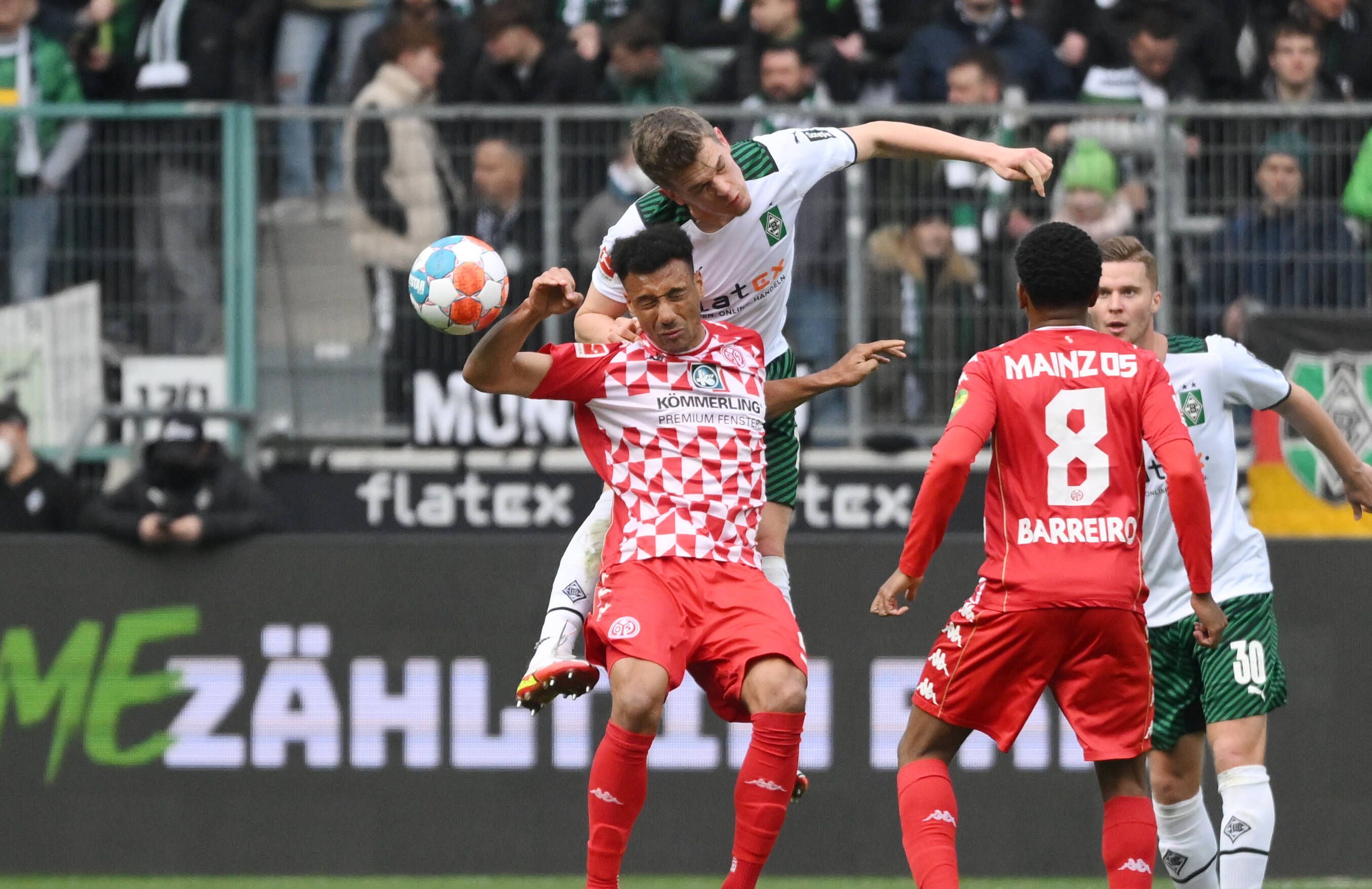 Matthias Ginter von Borussia Mönchengladbach im Luftkampf mit Karim Onisiwo von Mainz 05 im Borussia-Park (3. April 2022).