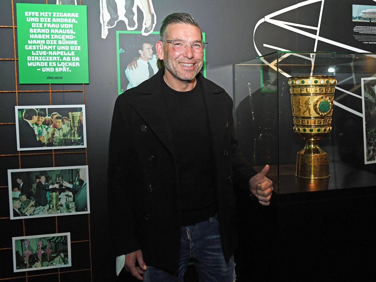 DFB-Pokalsieger und Torhüterlegende von Borussia Mönchengladbach, Uwe Kamps, in der Fohlen-Welt am 3. April 2022. Uwe Kamps steht lächelnd, mit dem linken Daumen nach oben, vor dem DFB-Pokal.