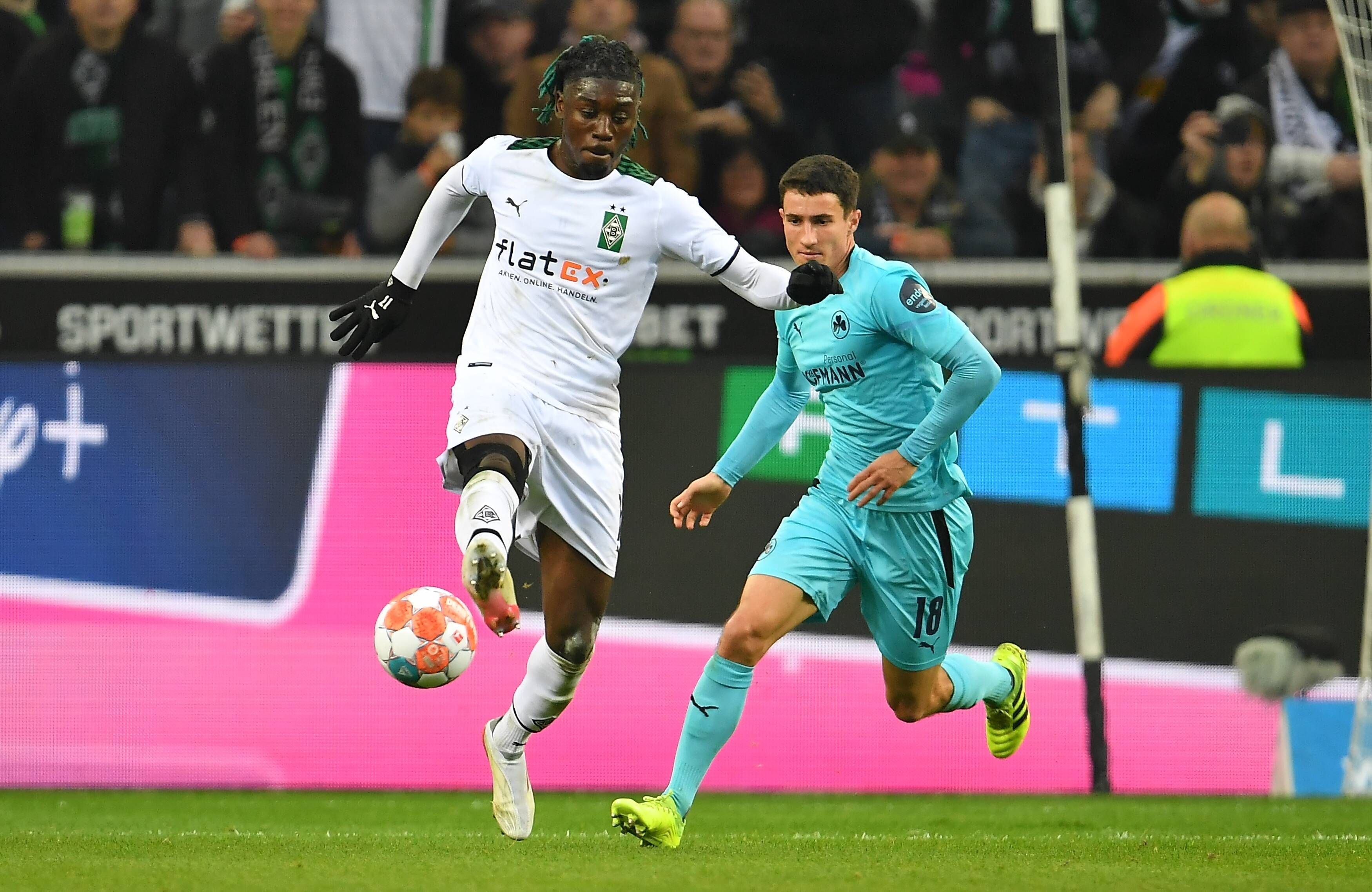 Manu Kone von Borussia Mönchengladbach im Duell mit Marco Meyerhöfer von Greuther Fürth im Bundesliga-Duell am 20. November 2021. Kone nimmt den Ball mit der rechten Fußsohle an. Hinter ihm läuft Meyerhöfer.