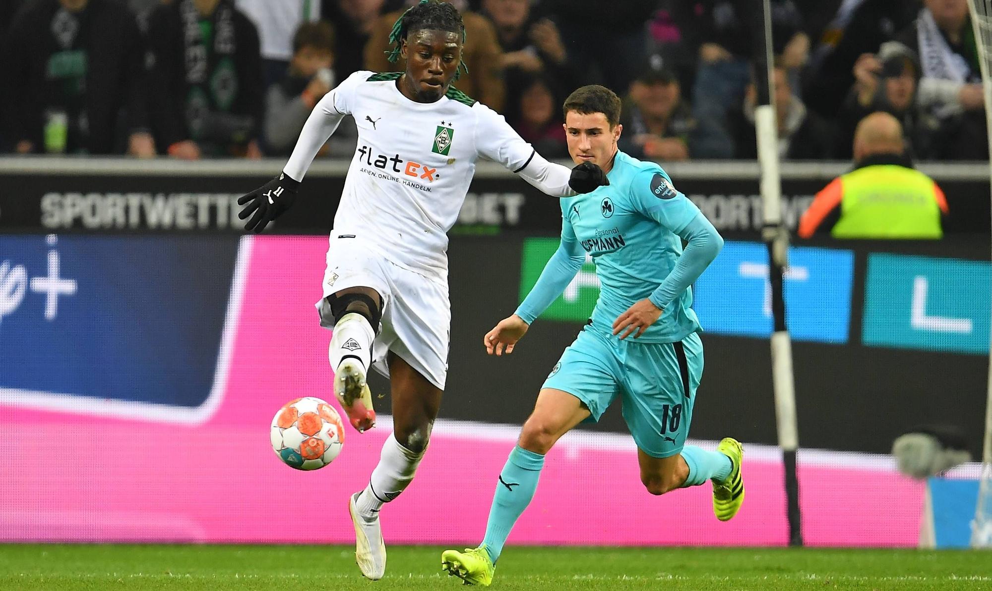 Manu Kone von Borussia Mönchengladbach im Duell mit Marco Meyerhöfer von Greuther Fürth im Bundesliga-Duell am 20. November 2021. Kone nimmt den Ball mit der rechten Fußsohle an. Hinter ihm läuft Meyerhöfer.