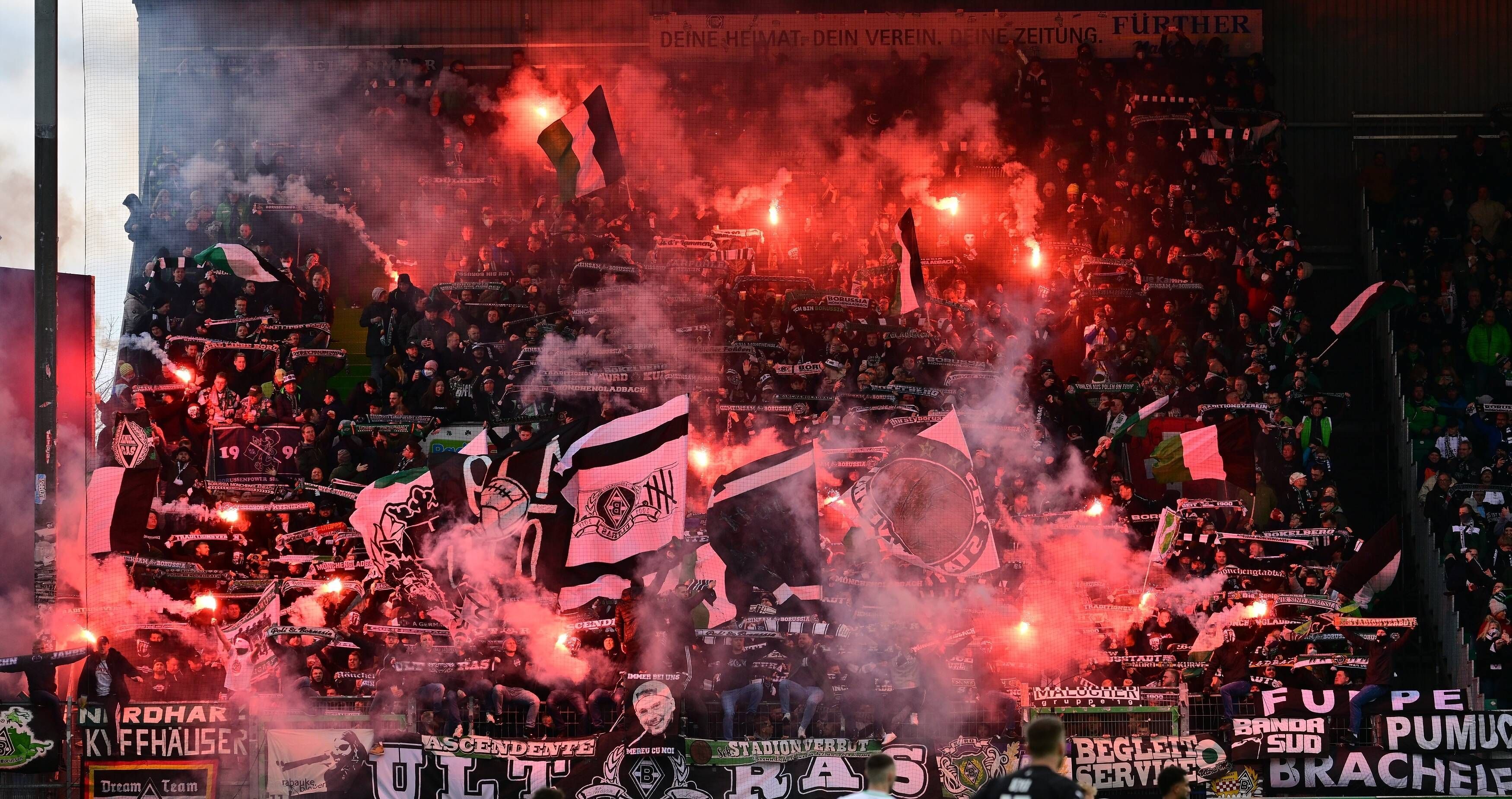 Fohlen-Fans im Gäste-Block während der Bundesliga-Partie zwischen Greuther und Borussia Mönchengladbach am 9. April 2022. Es sind Bengalos zu sehen.