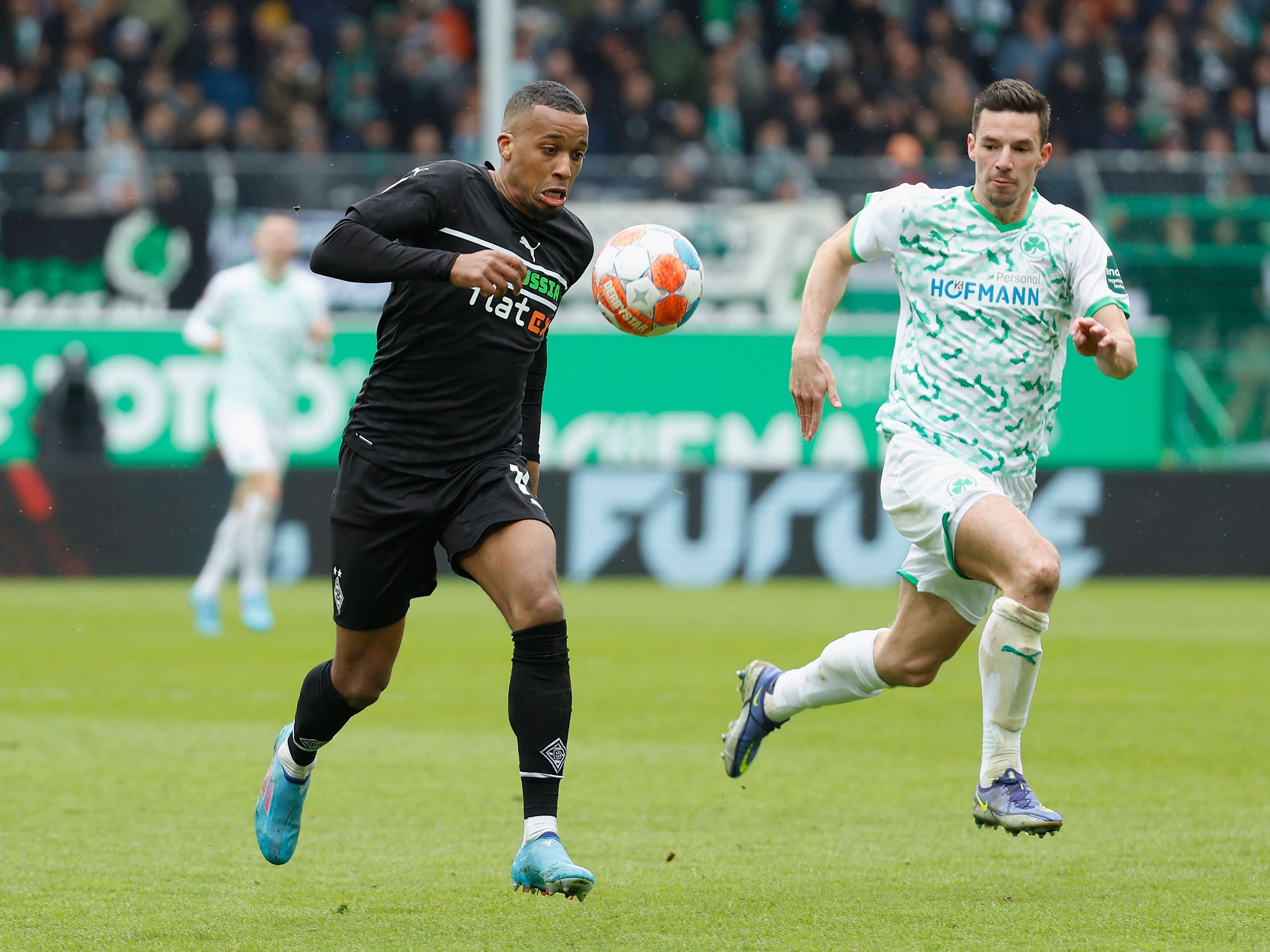 Stürmer Alassane Plea von Borussia Mönchengladbach im Laufduell mit Nick Viergever von Greuther Fürth am 09. April 2022. Plea hat den Ball.