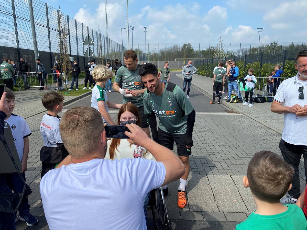 Lars Stindl, Kapitän von Borussia Mönchengladbach, posiert mit einem jungen Fohlen-Fan für ein Erinnerungsfoto. Im Hintergrund sieht man Tony Jantschke beim Schreiben von Autogrammen.