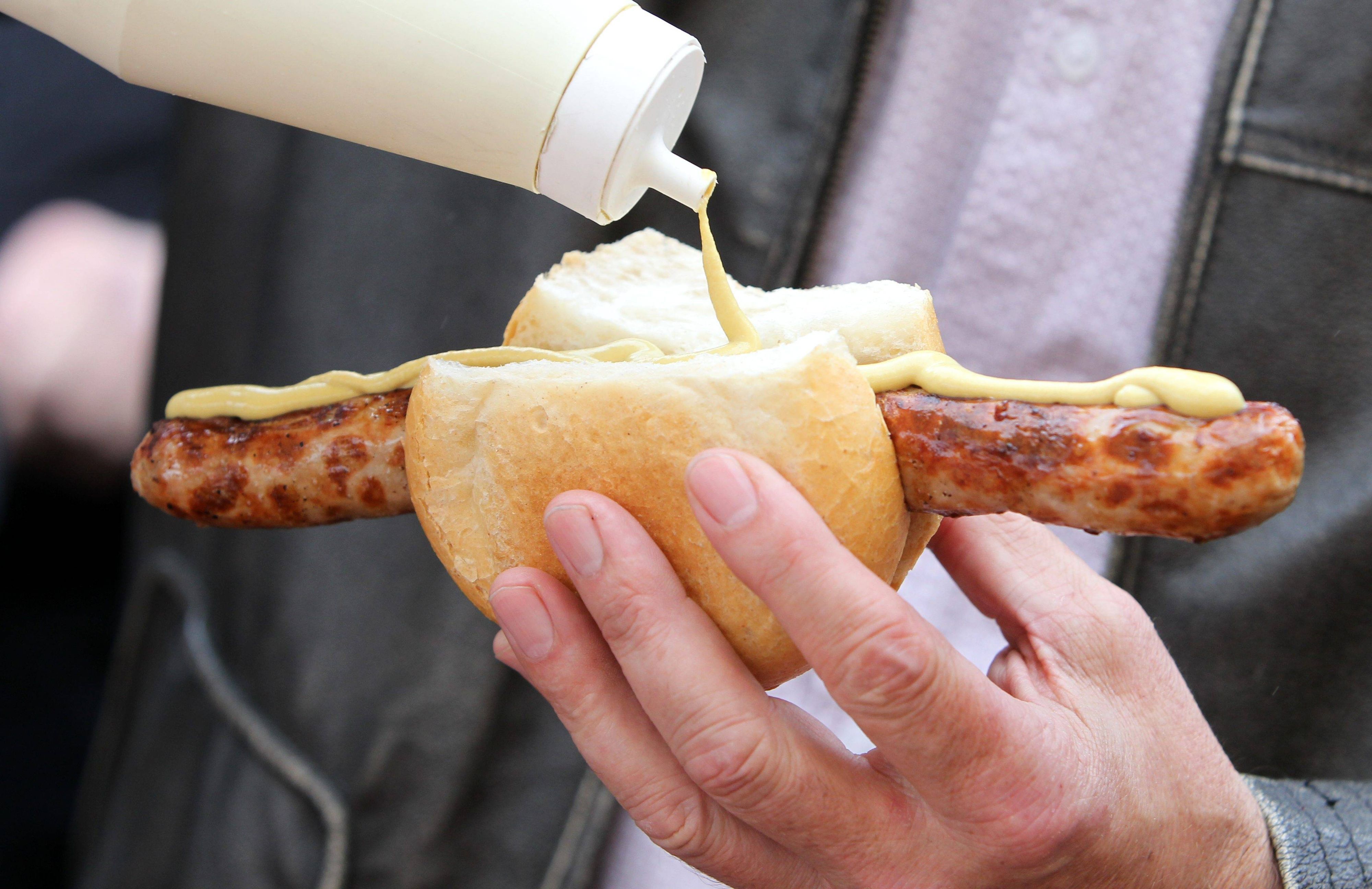 Eine Bratwurst im Brötchen mit Senf. Dieses Symbolfoto stammt vom 26. März 2011. Die Aufnahme wurde auf dem Erfurter Domplatz erstellt.