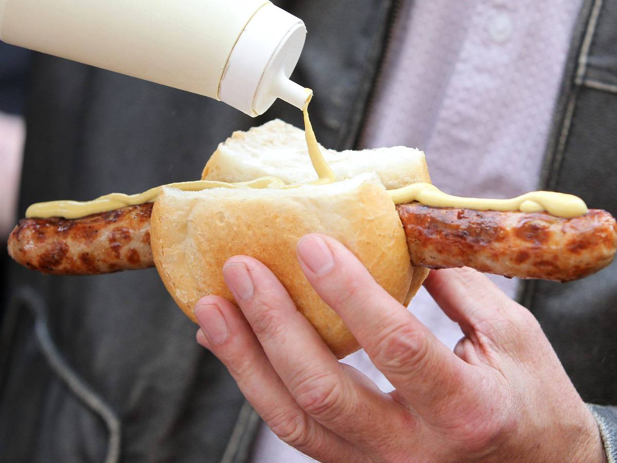 Eine Bratwurst im Brötchen mit Senf. Dieses Symbolfoto stammt vom 26. März 2011. Die Aufnahme wurde auf dem Erfurter Domplatz erstellt.