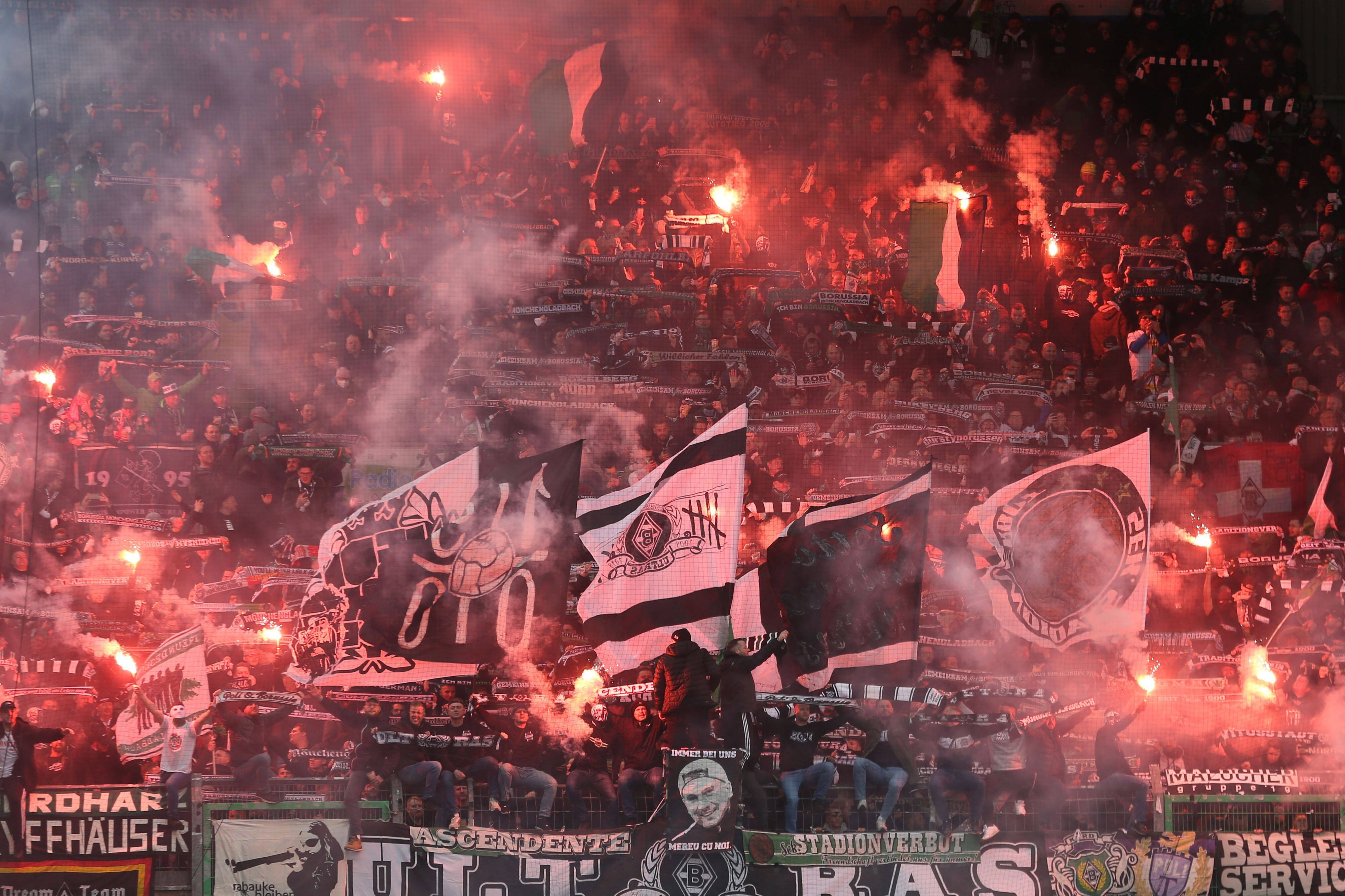 Ultras von Borussia Mönchengladbach zünden Bengalos an beim Bundesligaspiel der Fohlen-Elf im Stadion von Greuther Fürth am 9. April 2022. Andere Fans schwenken ihre Fahnen.