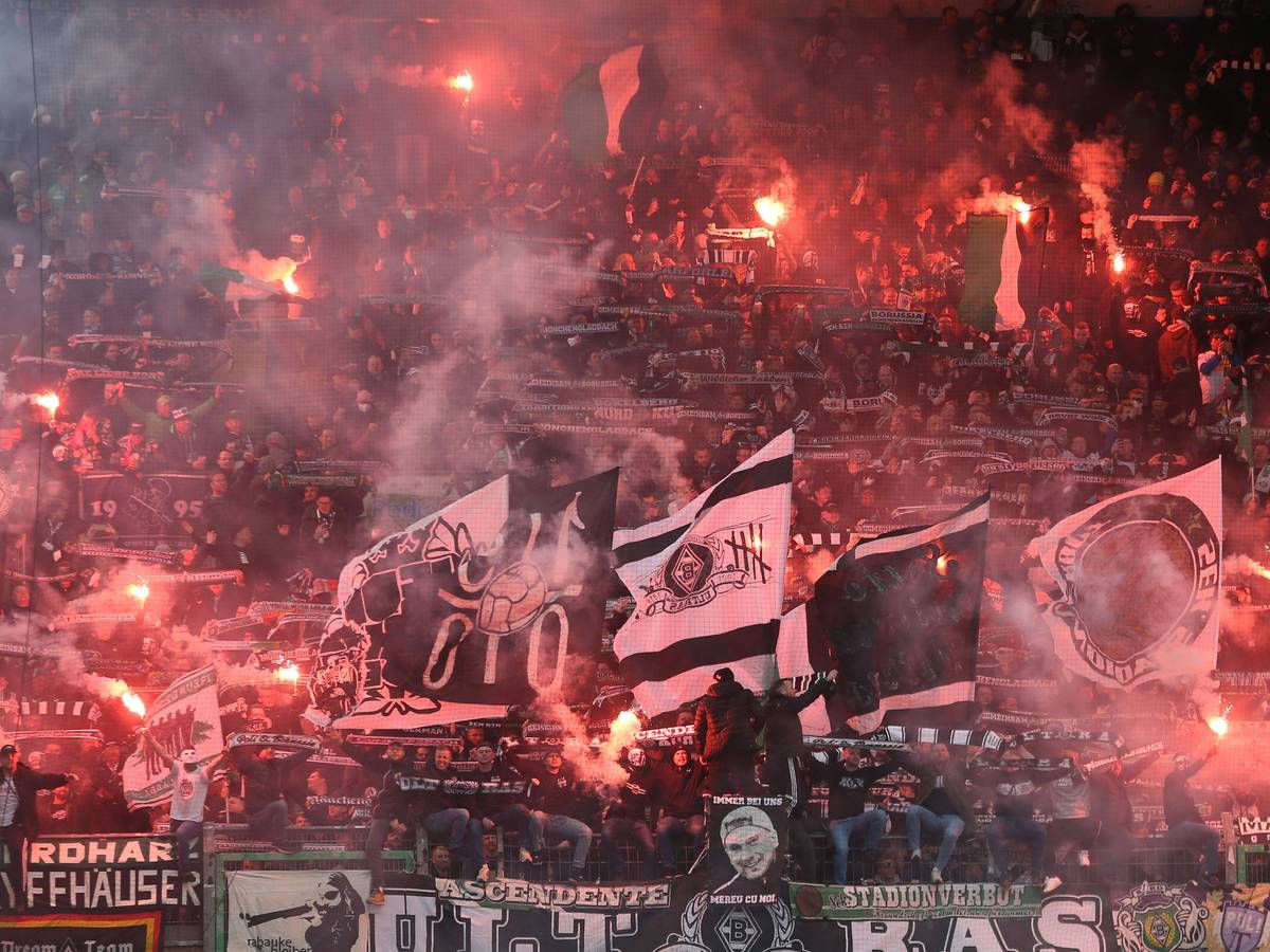 Ultras von Borussia Mönchengladbach zünden Bengalos an beim Bundesligaspiel der Fohlen-Elf im Stadion von Greuther Fürth am 9. April 2022. Andere Fans schwenken ihre Fahnen.