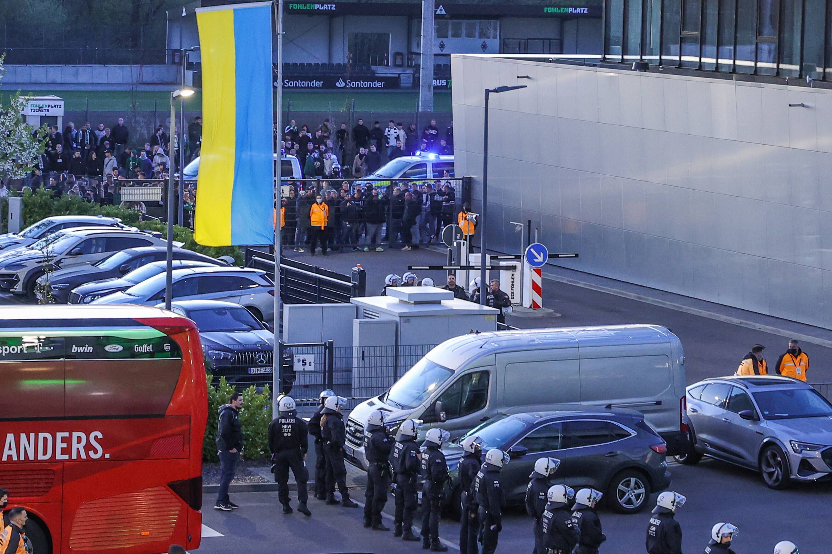 Ausnahmezustand im Borussia-Park (16. April 2022). Polizeikräfte sichern den Innenhof vor der Geschäftsstelle, nachdem wütende Ultras ein Tor aufgebrochen und Richtung Fohlen-Kabine gestürmt waren. Der Mannschaftsbus des 1. FC Köln ist auch zu sehen.