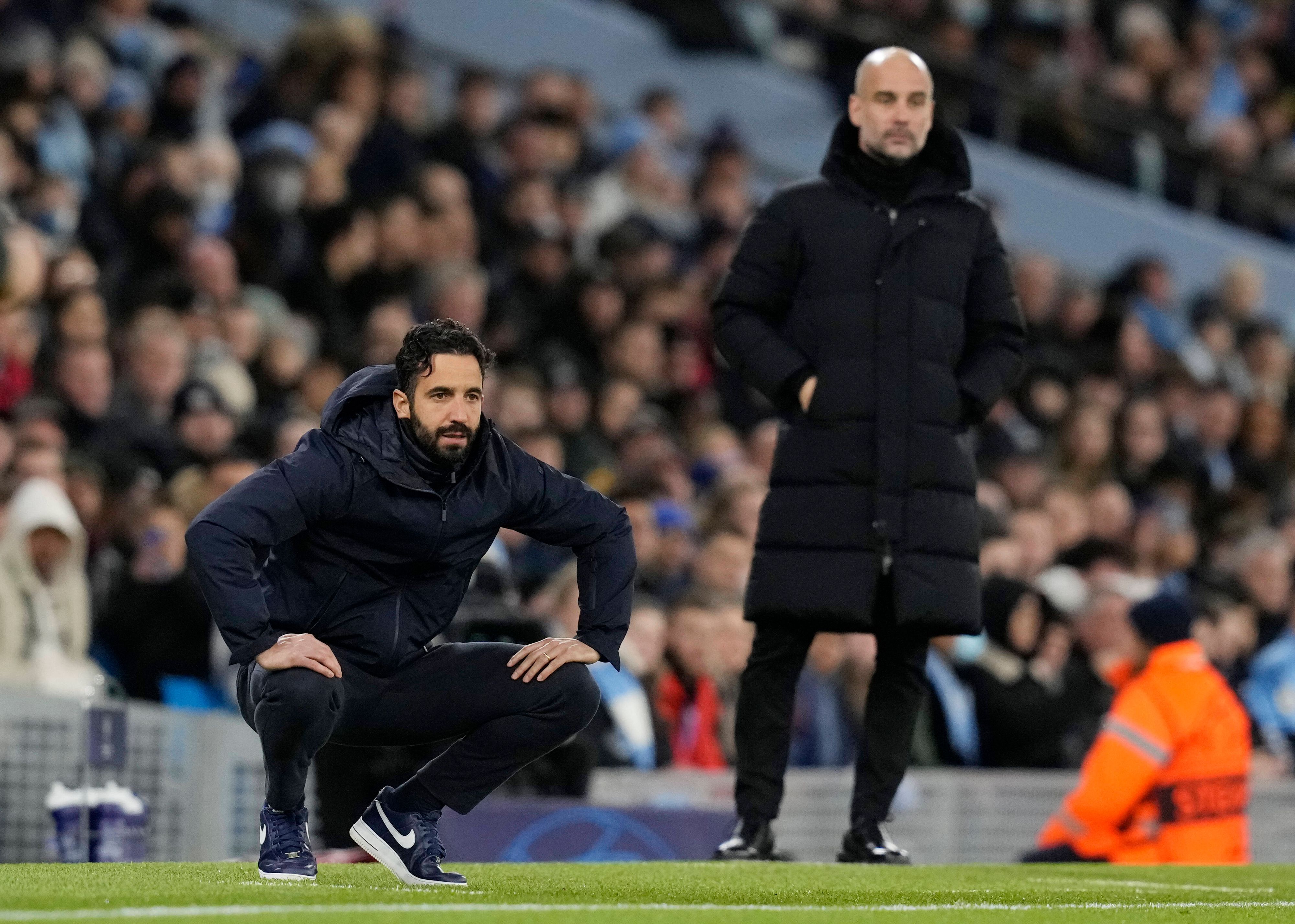 Rúben Amorim (l.), Trainer von Sporting Lissabon, an der Seitenlinie im „Etihad Stadium“ während des Champions-League-Duells gegen Manchester City am 9. März 2022. Im Hintergrund ist Pep Guardiola zu sehen. Rúben Amorim ist in die Hocke gegangen.