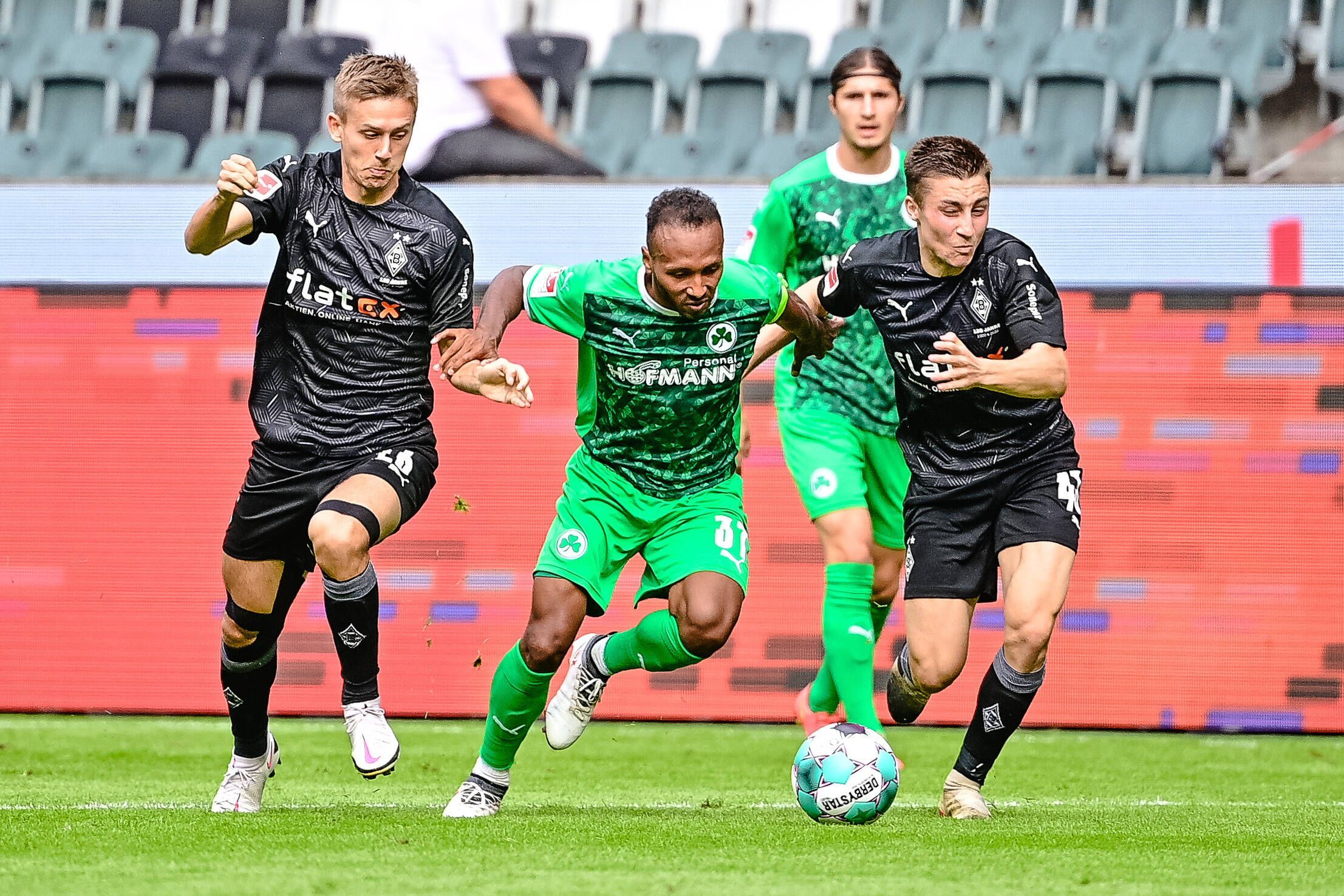 Torben Müsel (l.) und Rocco Reitz (r.) im Trikot von Fußball-Bundesligist Borussia Mönchen im Duell mit Julian Green (M.) von Greuther Fürth. Diese Aufnahme ist während eines Testspiels am 27. August 2020 im Borussia-Park entstanden. Alle drei Spieler kämpfen um den Ball.