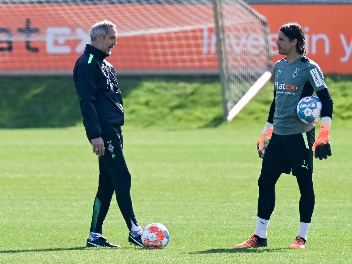 Gladbach-Cheftrainer Adi Hütter (l.) im Gespräch mit Torhüter Yann Sommer (r.) während einer Trainingseinheit am 19. April 2022 im Borussia-Park. Sommer hält einen Ball im Arm.