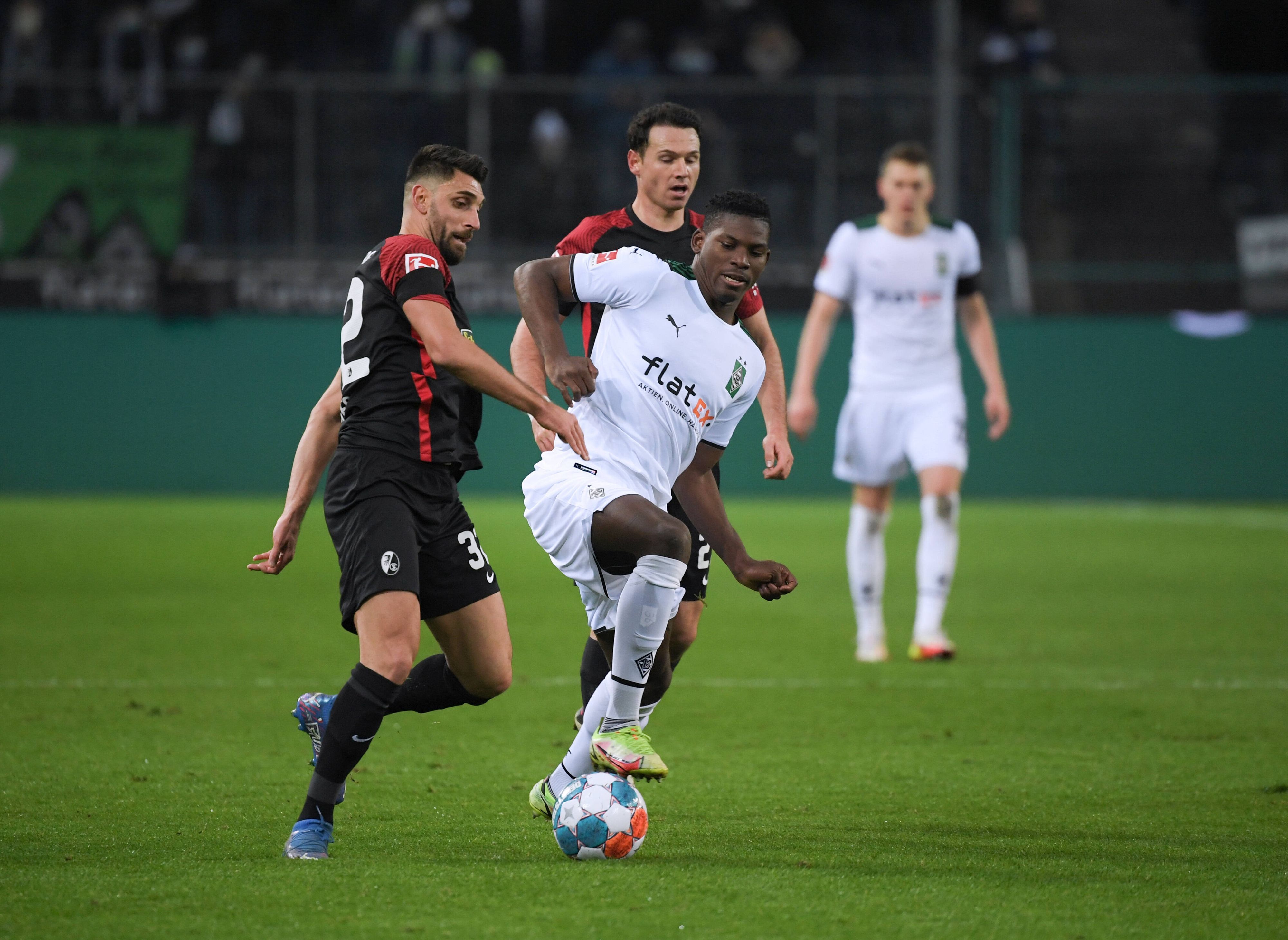 Vincenzo Grifo (l.) und Nicolas Höfler (r.) vom SC Freiburg im Zweikampf mit Breel Embolo von Borussia Mönchengladbach im Hinspiel am 05. Dezember 2022.