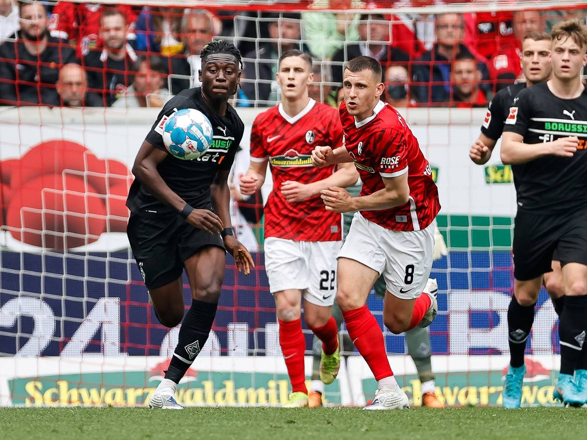 Kouadio Kone von Borussia Moenchengladbach im Kampf um den Ball mit Roland Sallai und Maximilian Eggestein vom SC Freiburg