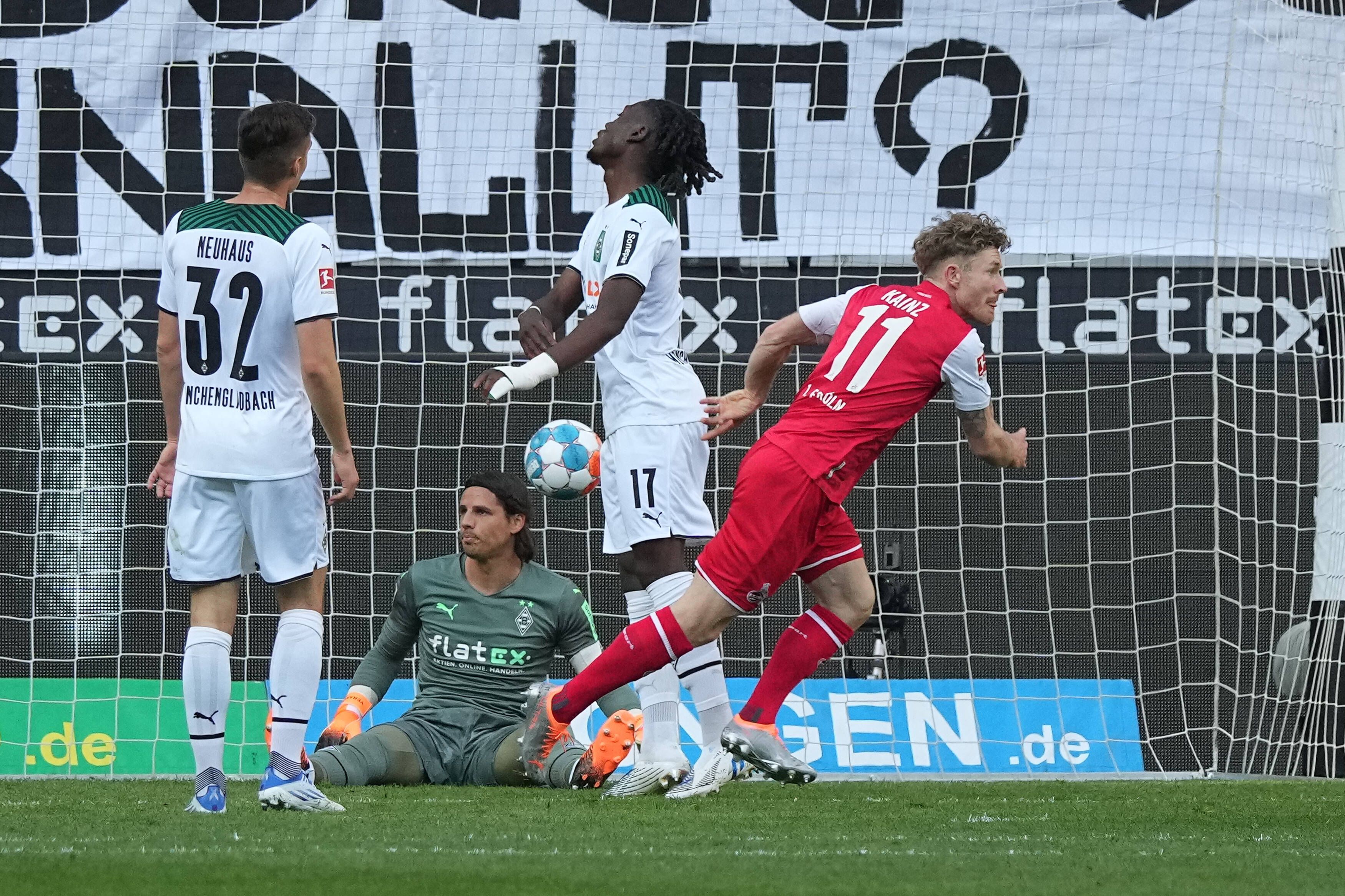 Gladbach-Schlussmann Yann Sommer (2.v.l.) sitzt nach einem Gegentreffer im Derby gegen den 1. FC Köln (16. April 2022) enttäuscht auf dem Boden. Seine Teamkollegen Florian Neuhaus (l.) und Manu Koné (2.v.r.) ärgern sich ebenfalls, Florian Kainz (r.) jubelt. Im Hintergrund ist der Ball im Tor.