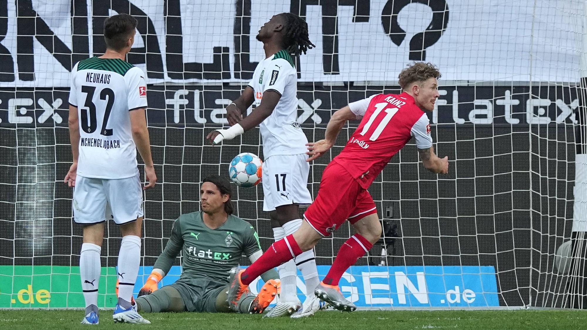 Gladbach-Schlussmann Yann Sommer (2.v.l.) sitzt nach einem Gegentreffer im Derby gegen den 1. FC Köln (16. April 2022) enttäuscht auf dem Boden. Seine Teamkollegen Florian Neuhaus (l.) und Manu Koné (2.v.r.) ärgern sich ebenfalls, Florian Kainz (r.) jubelt. Im Hintergrund ist der Ball im Tor.