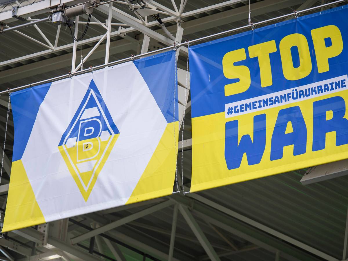 Zwei blau-gelbe Wappen mit Borussia-Logo und Anti-Kriegs-Slogan am 3. April 2022 im Borussia-Park.