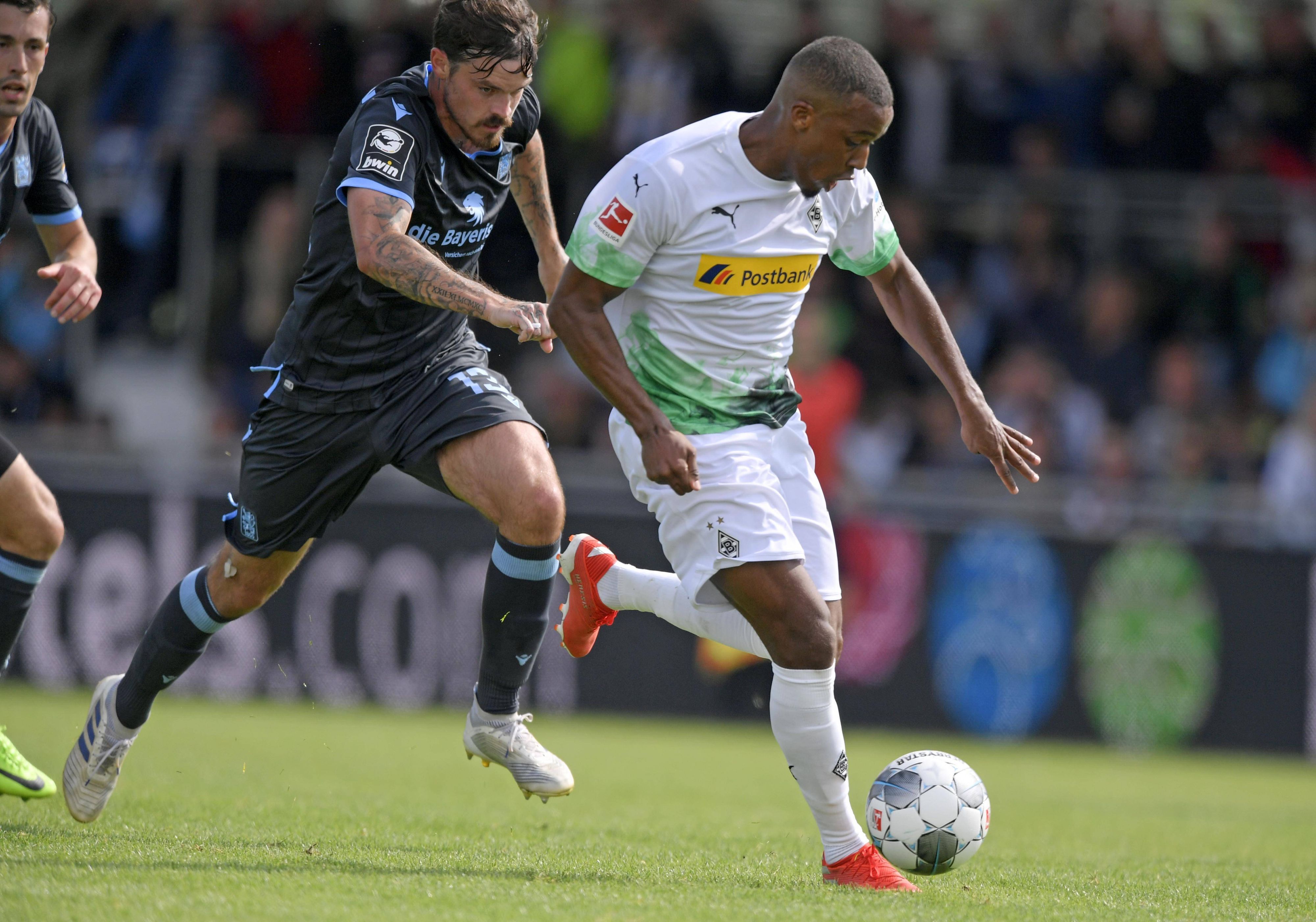 Borussia Mönchengladbach trifft in der Sommer-Vorbereitung auf den TSV 1860 München. Das Foto zeigt Gladbachs Alassane Plea (r.) bei einem früheren Testspiel am 13. Juli 2019 im Zweikampf gegen Dennis Erdmann (l.).