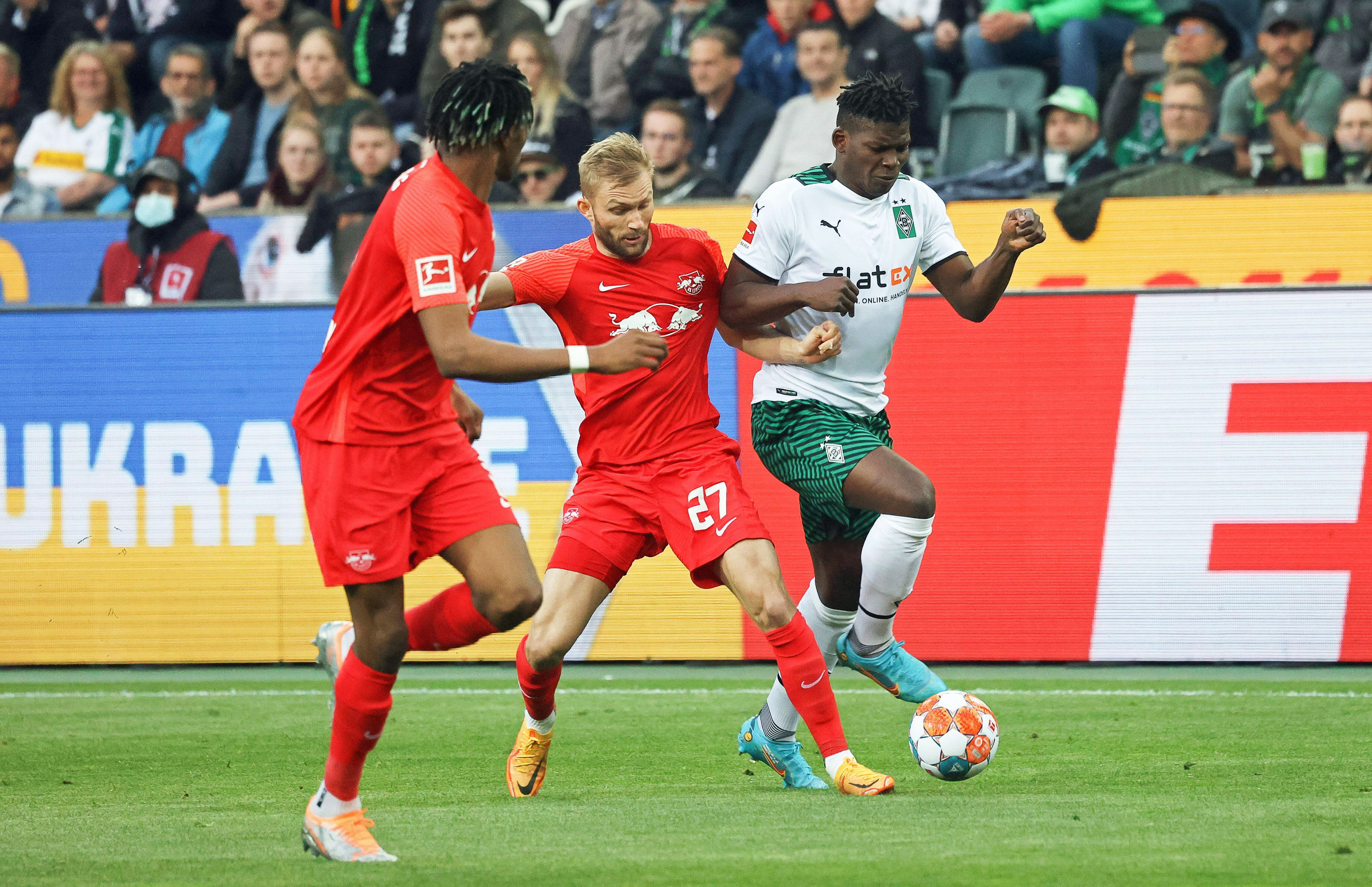 Gladbach-Stürmer Breel Embolo (r.) im Duell mit Konrad Laimer (M.) von RB Leipzig während des Bundesliga-Duells am Montag (2. Mai 2022) im Borussia-Park. Beide Spieler haben den Ball im Blick.