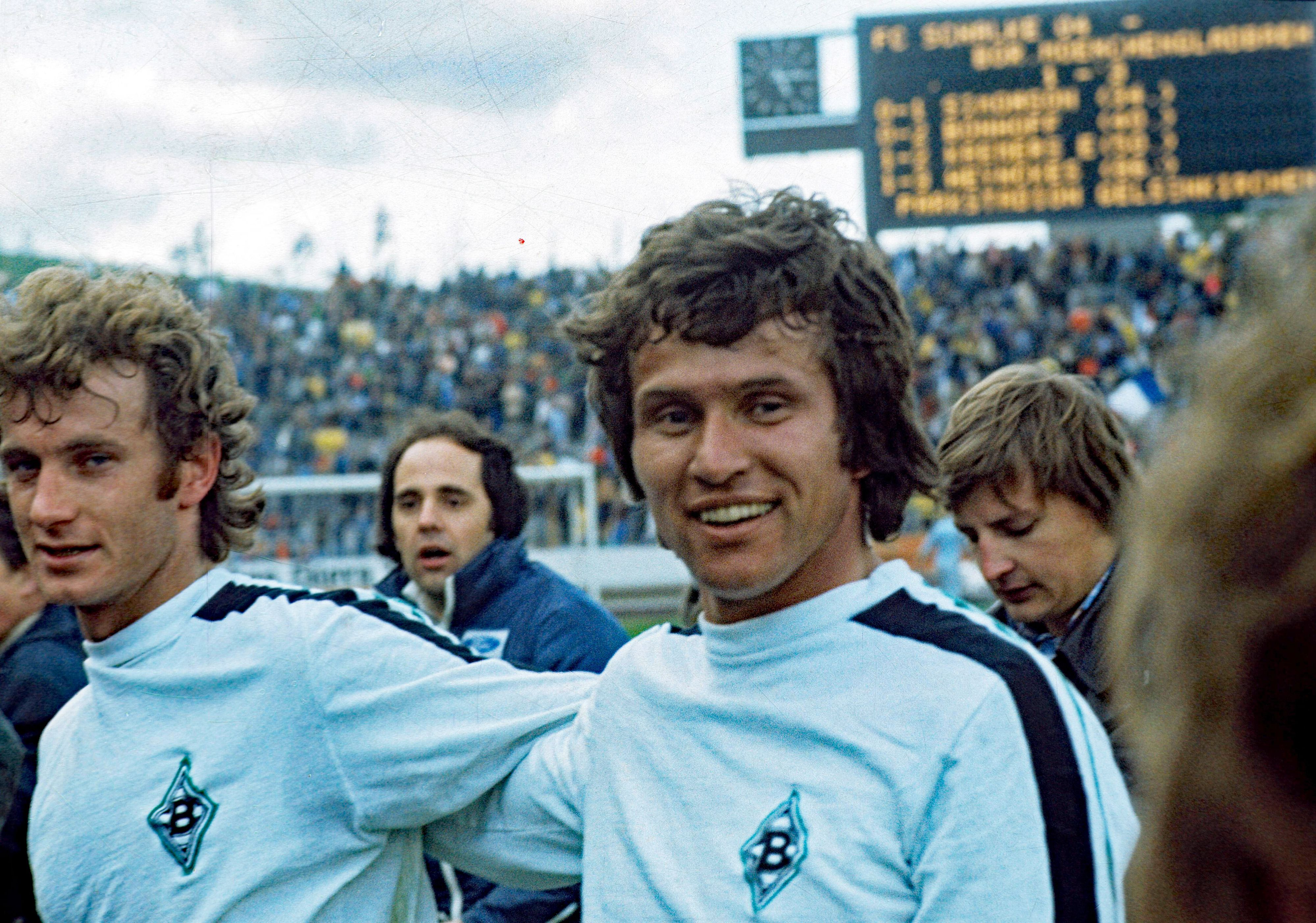 Jupp Heynckes (r.) von Borussia Mönchengladbach mit Team-Kollege Rainer Bonhof (l.) am 16. April 1977 in Gelsenkirchen. Heynckes lächelt.
