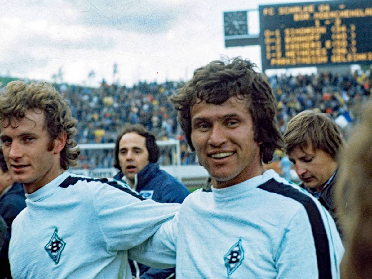 Jupp Heynckes (r.) von Borussia Mönchengladbach mit Team-Kollege Rainer Bonhof (l.) am 16. April 1977 in Gelsenkirchen. Heynckes lächelt.
