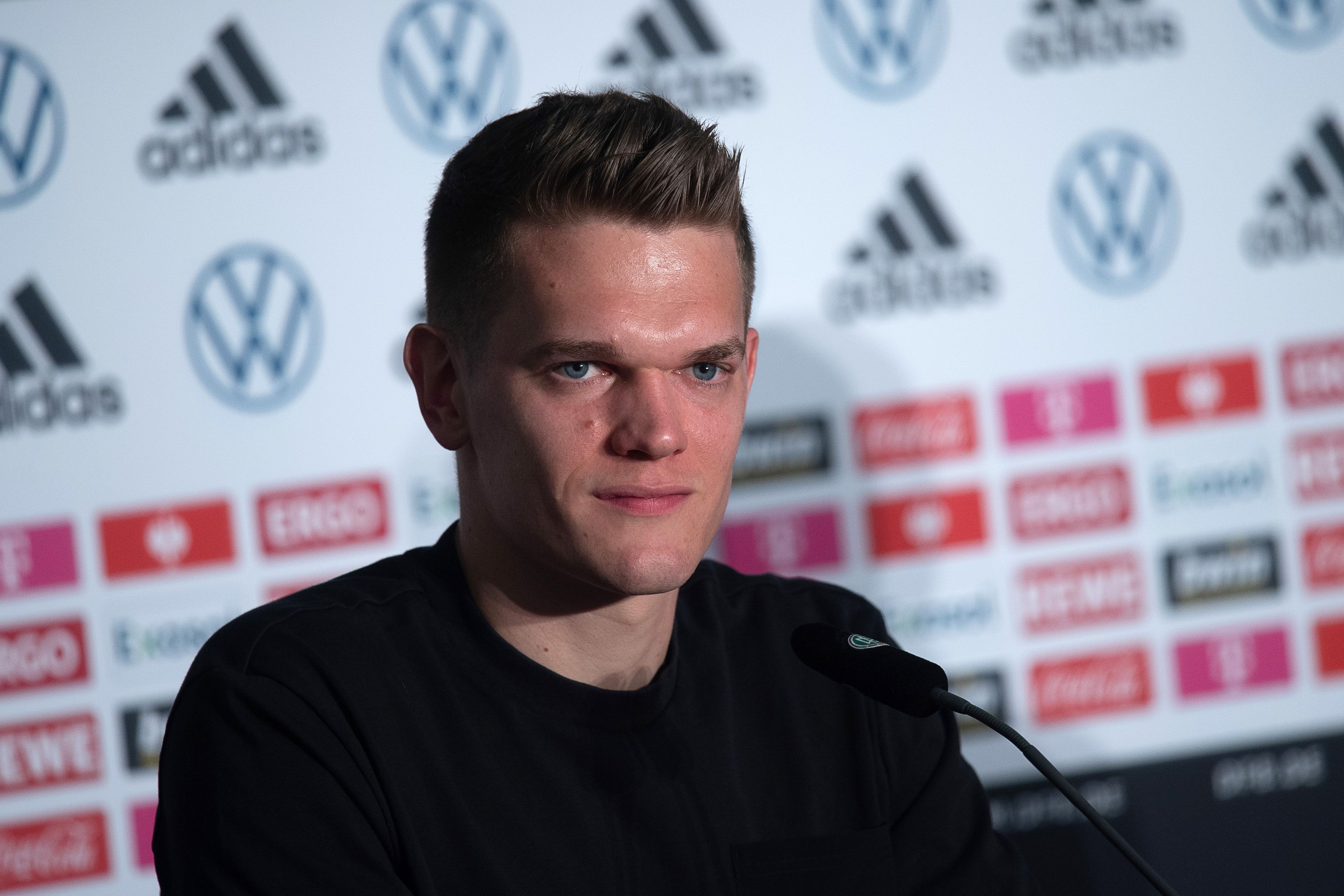 Verteidiger Matthias Ginter spricht bei einer Pressekonferenz der deutschen Fußball-Nationalmannschaft am 23. März 2022. Ginter lächelt.