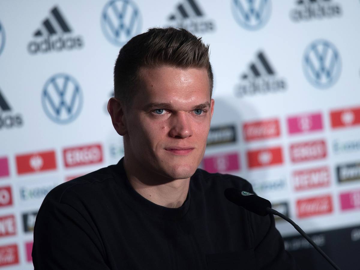 Verteidiger Matthias Ginter spricht bei einer Pressekonferenz der deutschen Fußball-Nationalmannschaft am 23. März 2022. Ginter lächelt.