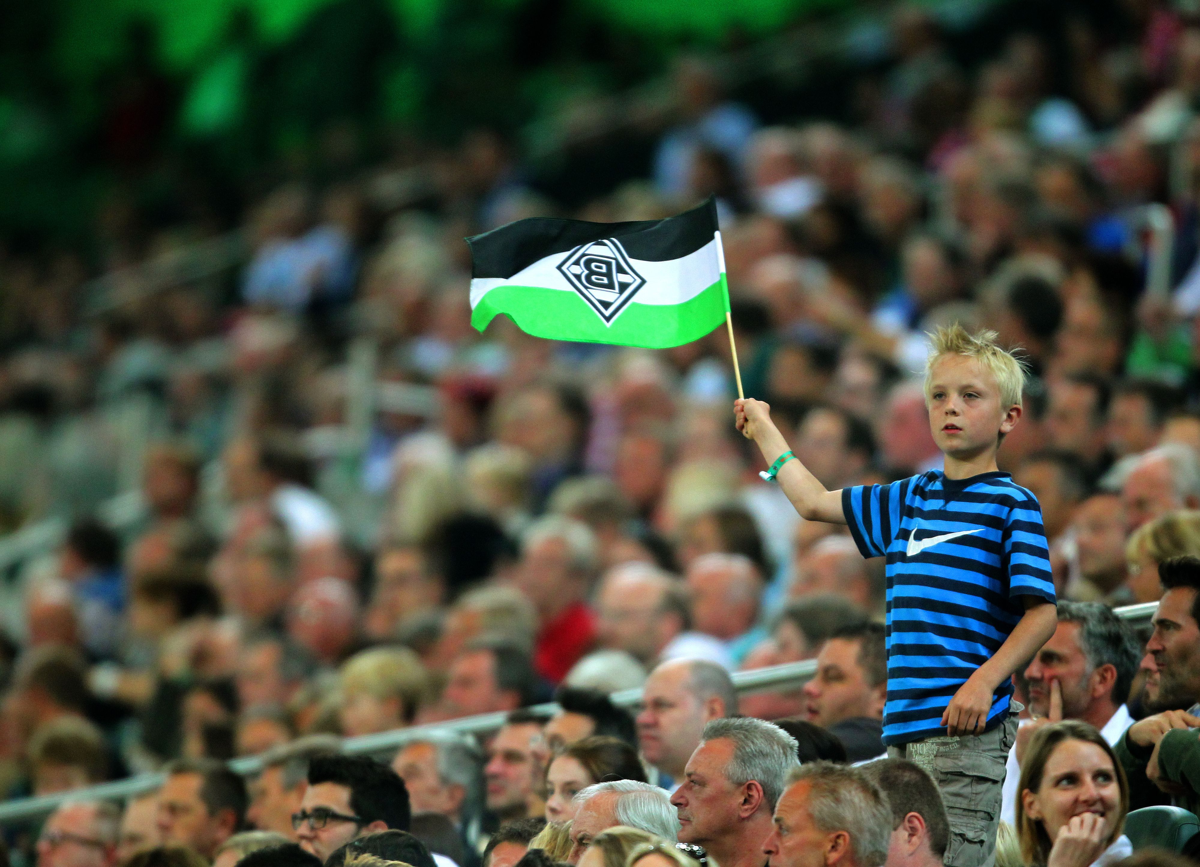Zuschauerinnen und Zuschauer im Borussia-Park. Dieses Fan-Foto stammt von der Partie zwischen Borussia Mönchengladbach und dem VfL Wolfsburg am 19. August 2011. Ein junger Fan schwenkt seine Gladbach-Fahne.
