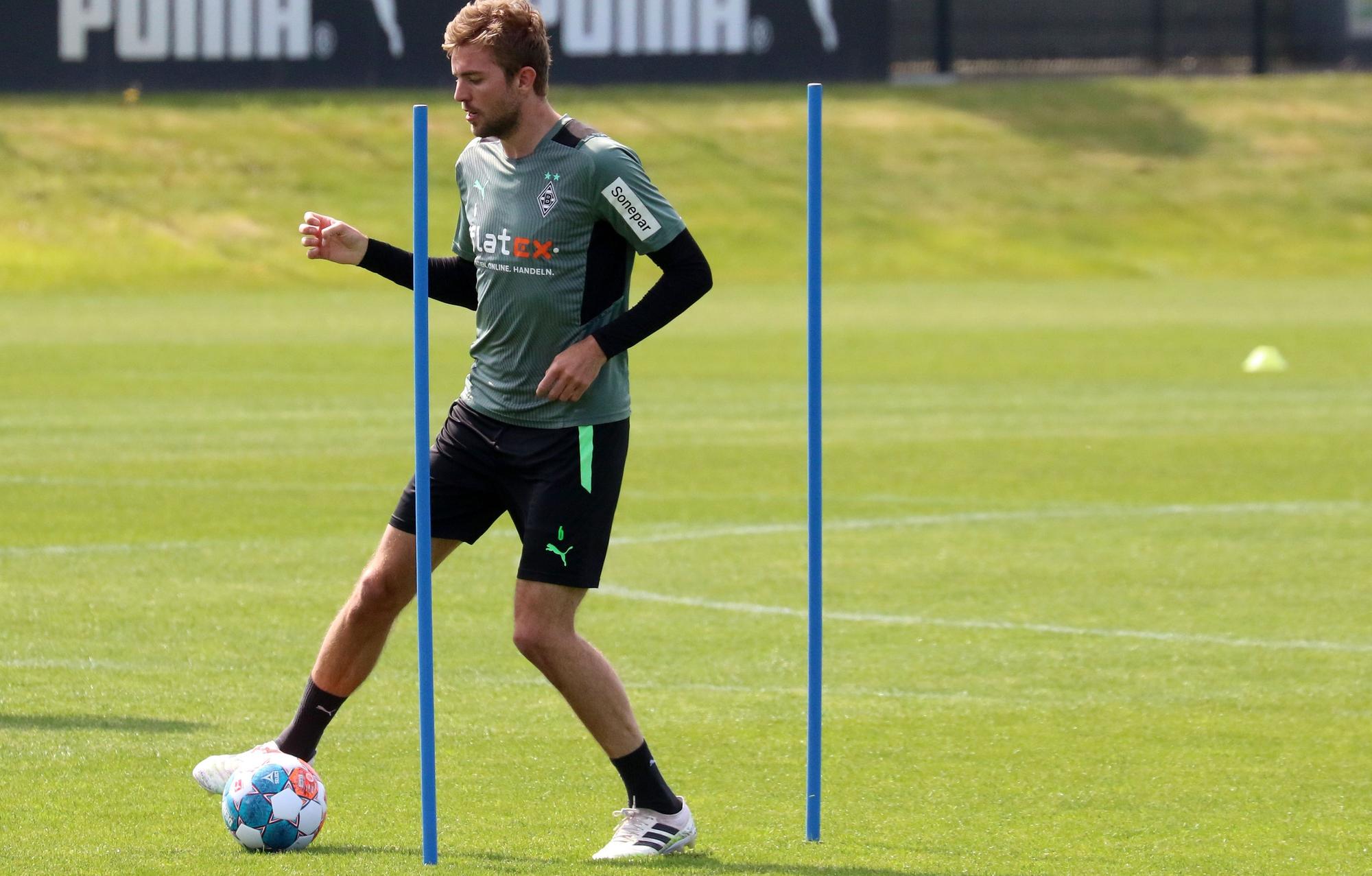 Christoph Kramer von Borussia Mönchengladbach am 5. Mai 2022 während des Profi-Trainings im Borussia-Park. Der Mittelfeldspieler umkurvt mit dem Ball am Fuß einige Übungsstangen.