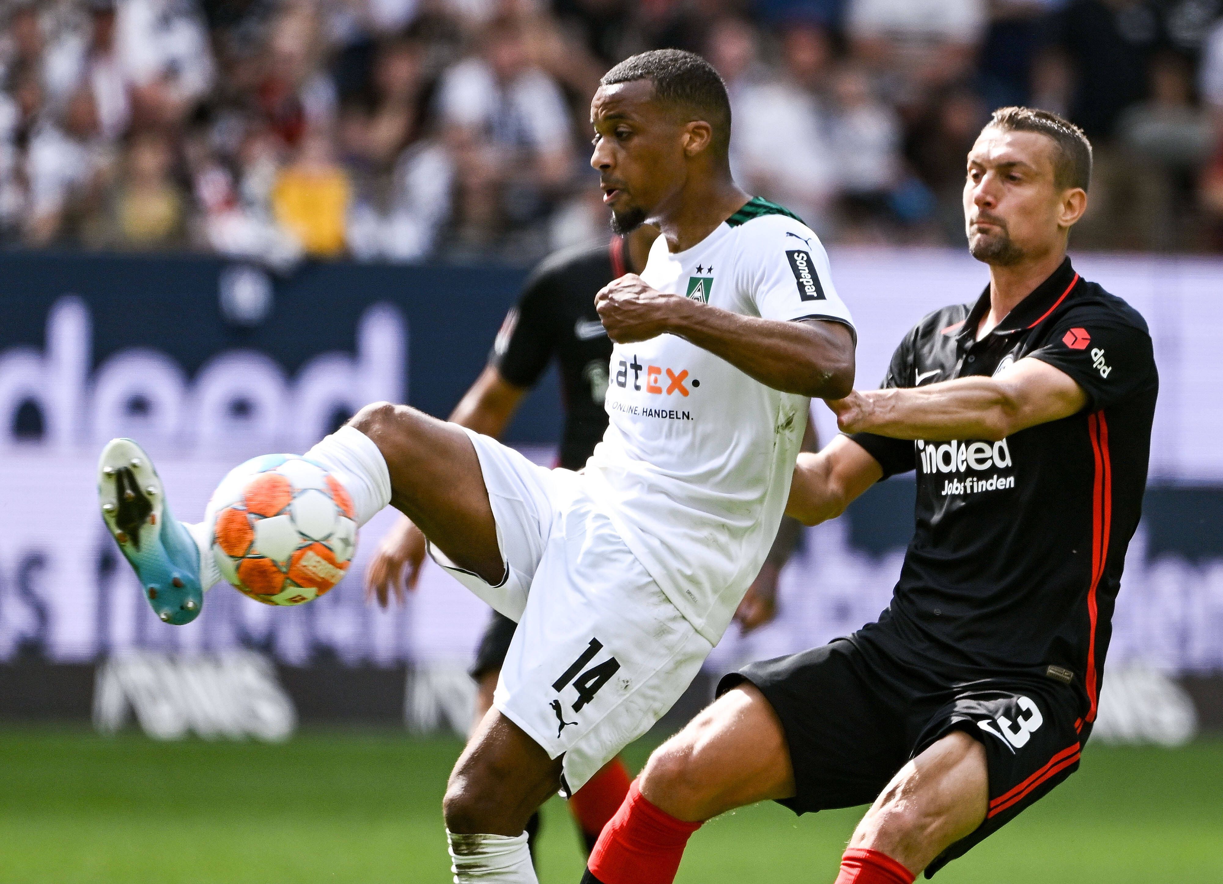 Alassane Plea, Stürmer von Borussia Mönchengladbach, im Duell mit Stefan Ilsanker von Eintracht Frankfurt während der Bundesligapartie zwischen beiden Teams am Sonntag (8. Mai 2022). Plea hat den Fuß am Ball.