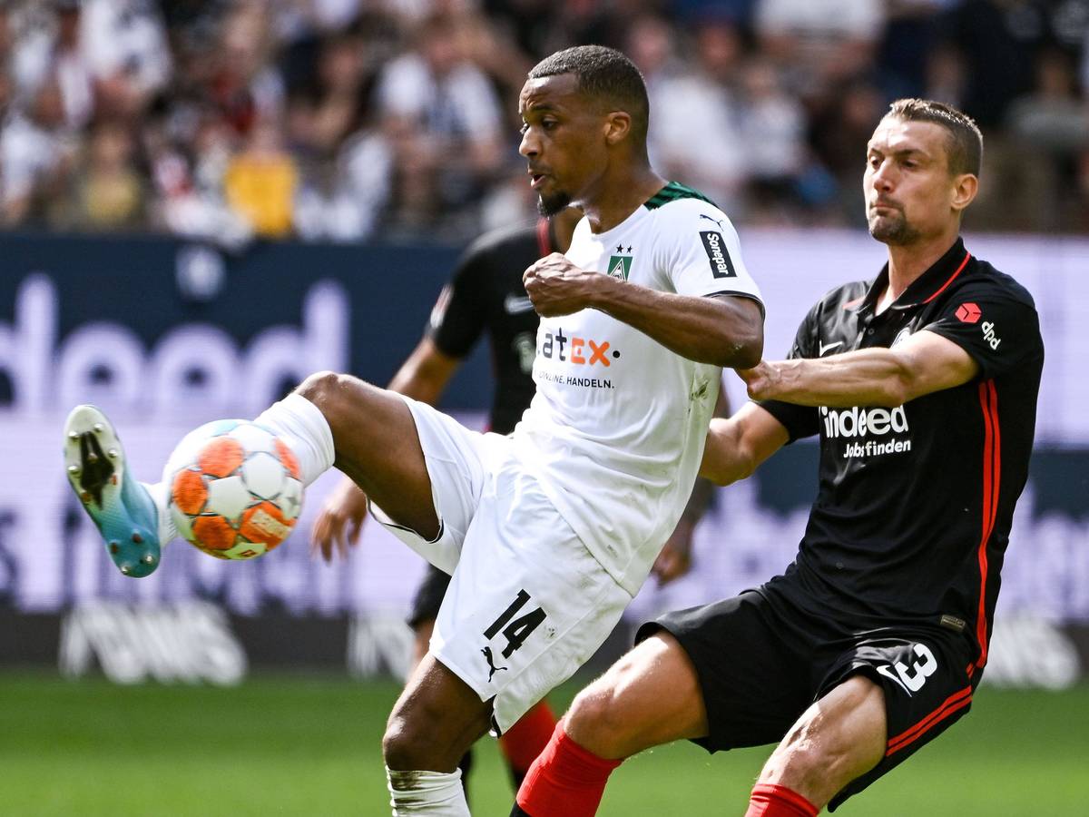 Alassane Plea, Stürmer von Borussia Mönchengladbach, im Duell mit Stefan Ilsanker von Eintracht Frankfurt während der Bundesligapartie zwischen beiden Teams am Sonntag (8. Mai 2022). Plea hat den Fuß am Ball.
