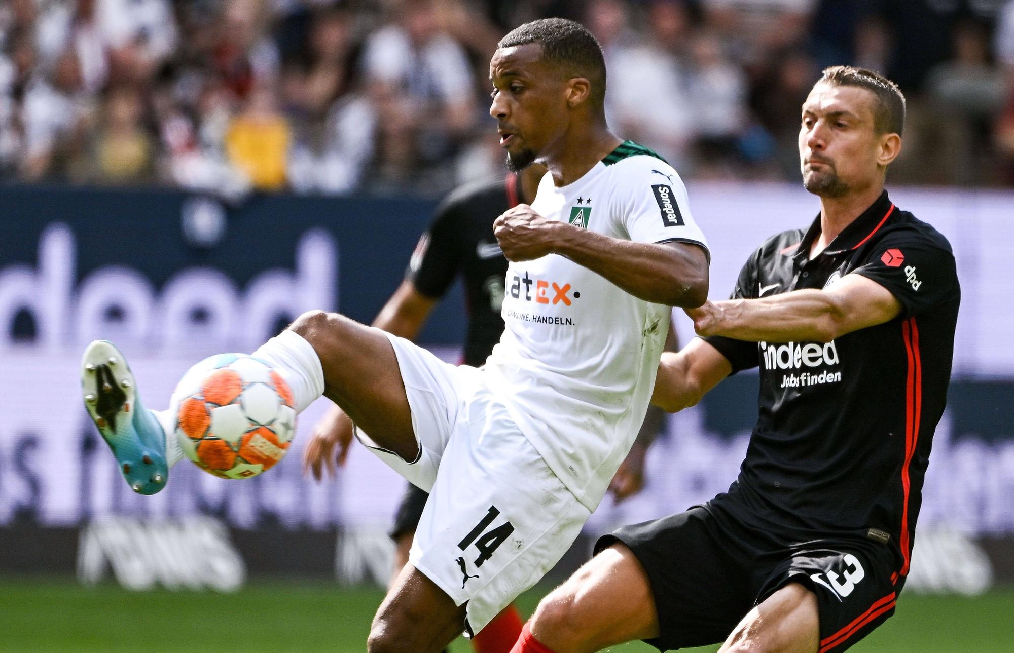 Alassane Plea, Stürmer von Borussia Mönchengladbach, im Duell mit Stefan Ilsanker von Eintracht Frankfurt während der Bundesligapartie zwischen beiden Teams am Sonntag (8. Mai 2022). Plea hat den Fuß am Ball.