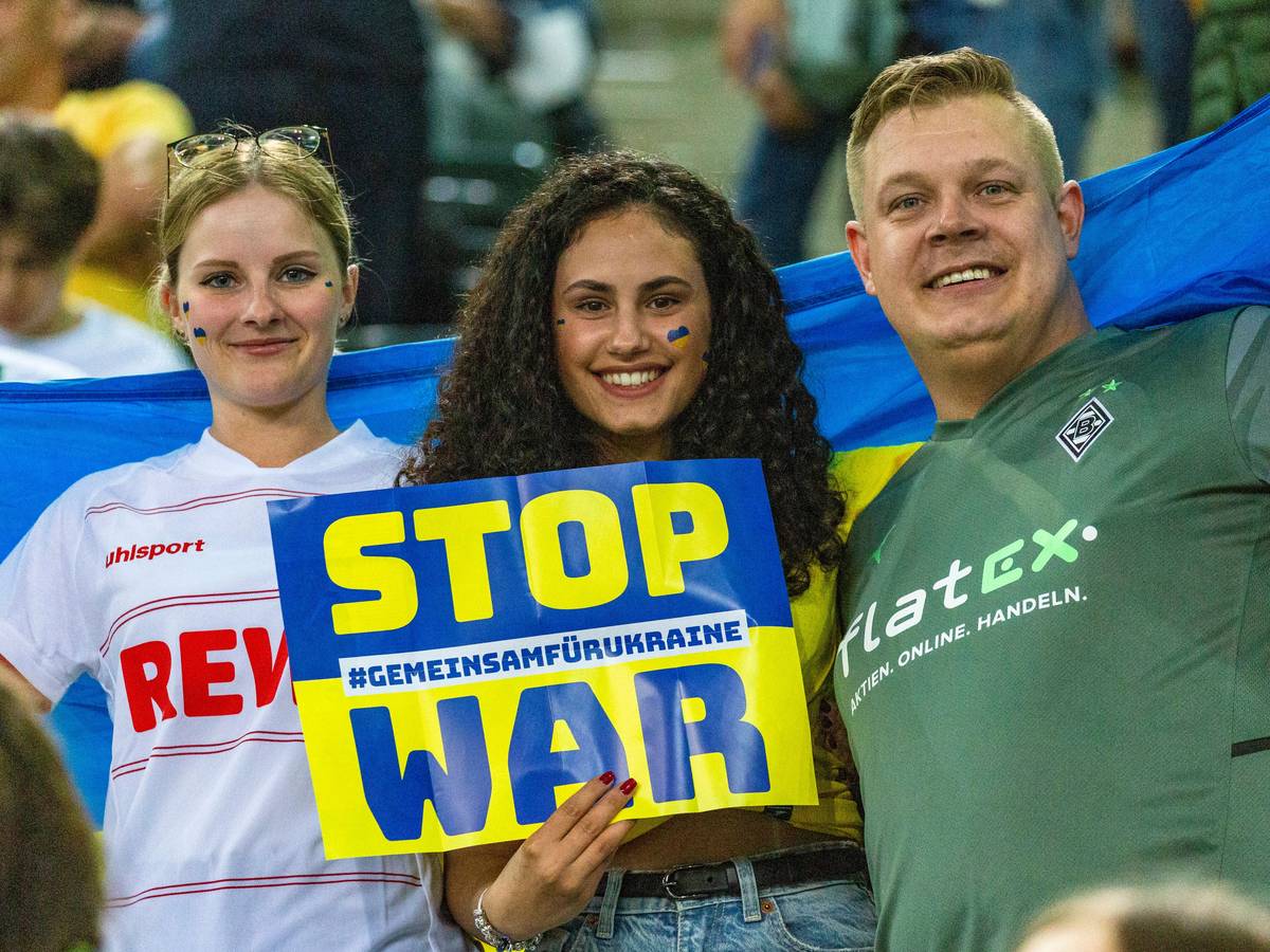 „Stop War“-Aufforderung von ukrainischen und deutschen Zuschauerinnen und Zuschauer während des Benefizspiels von Borussia Mönchengladbach gegen die Nationalmannschaft der Ukraine am 11. Mai 2022 im Borussia-Park. Auch eine Anhängerin des 1. FC Köln ist dabei.