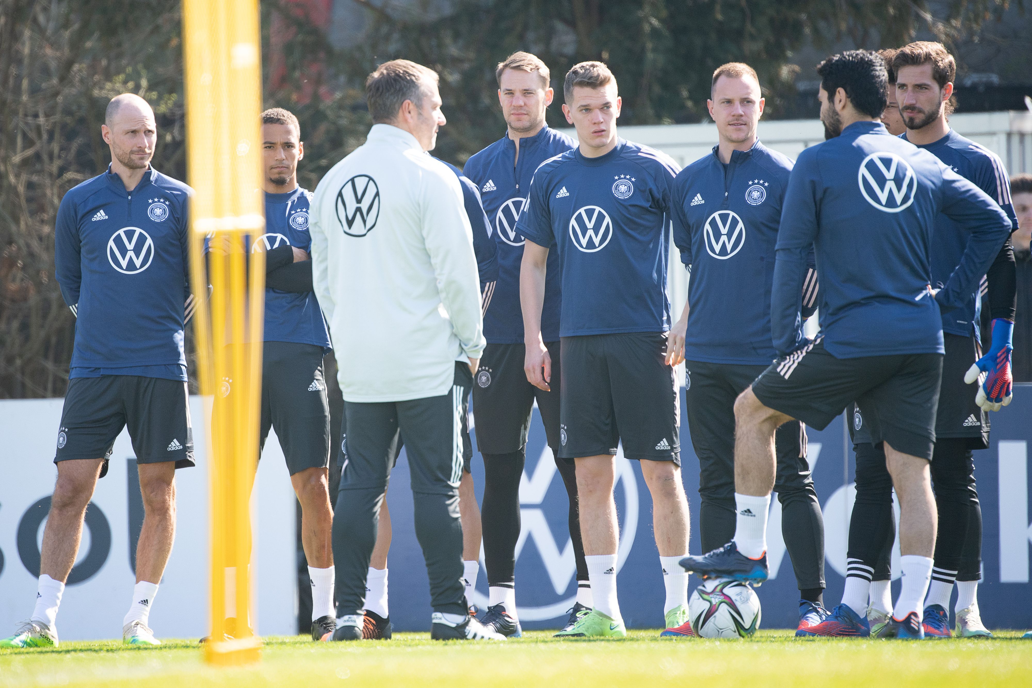 Bundestrainer Hansi Flick spricht mit seinen Spielern, links hört der ehemalige Nationalspieler Benedikt Höwedes, der das Teammanagement bei der Nationalmannschaft verstärkt, mit zu.