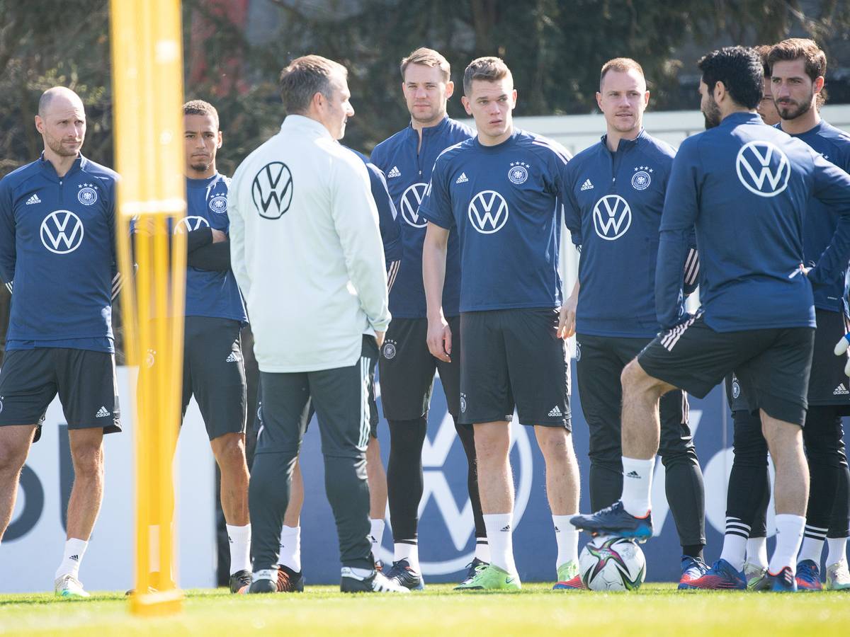 Bundestrainer Hansi Flick spricht mit seinen Spielern, links hört der ehemalige Nationalspieler Benedikt Höwedes, der das Teammanagement bei der Nationalmannschaft verstärkt, mit zu.