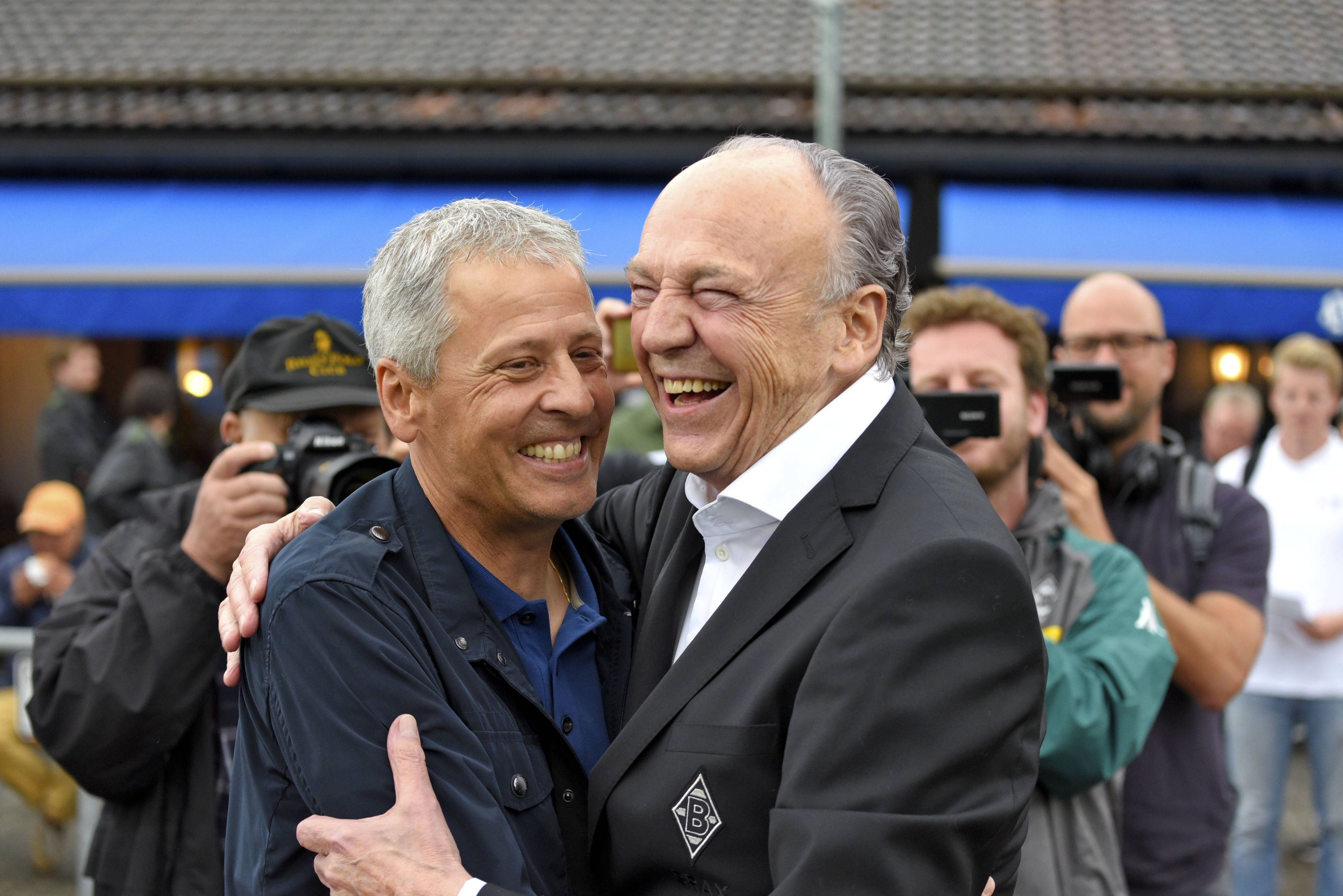 Lucien Favre zusammen mit Präsident Rolf Königs am 20. Juli 2017 bei einem Testspiel von Borussia Mönchengladbach gegen OGC Nizza. Beide umarmen sich und lachen gemeinsam.