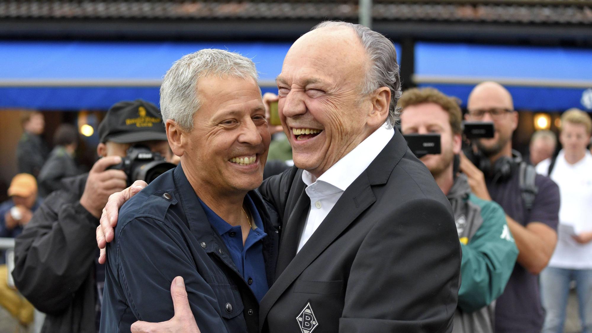 Lucien Favre zusammen mit Präsident Rolf Königs am 20. Juli 2017 bei einem Testspiel von Borussia Mönchengladbach gegen OGC Nizza. Beide umarmen sich und lachen gemeinsam.