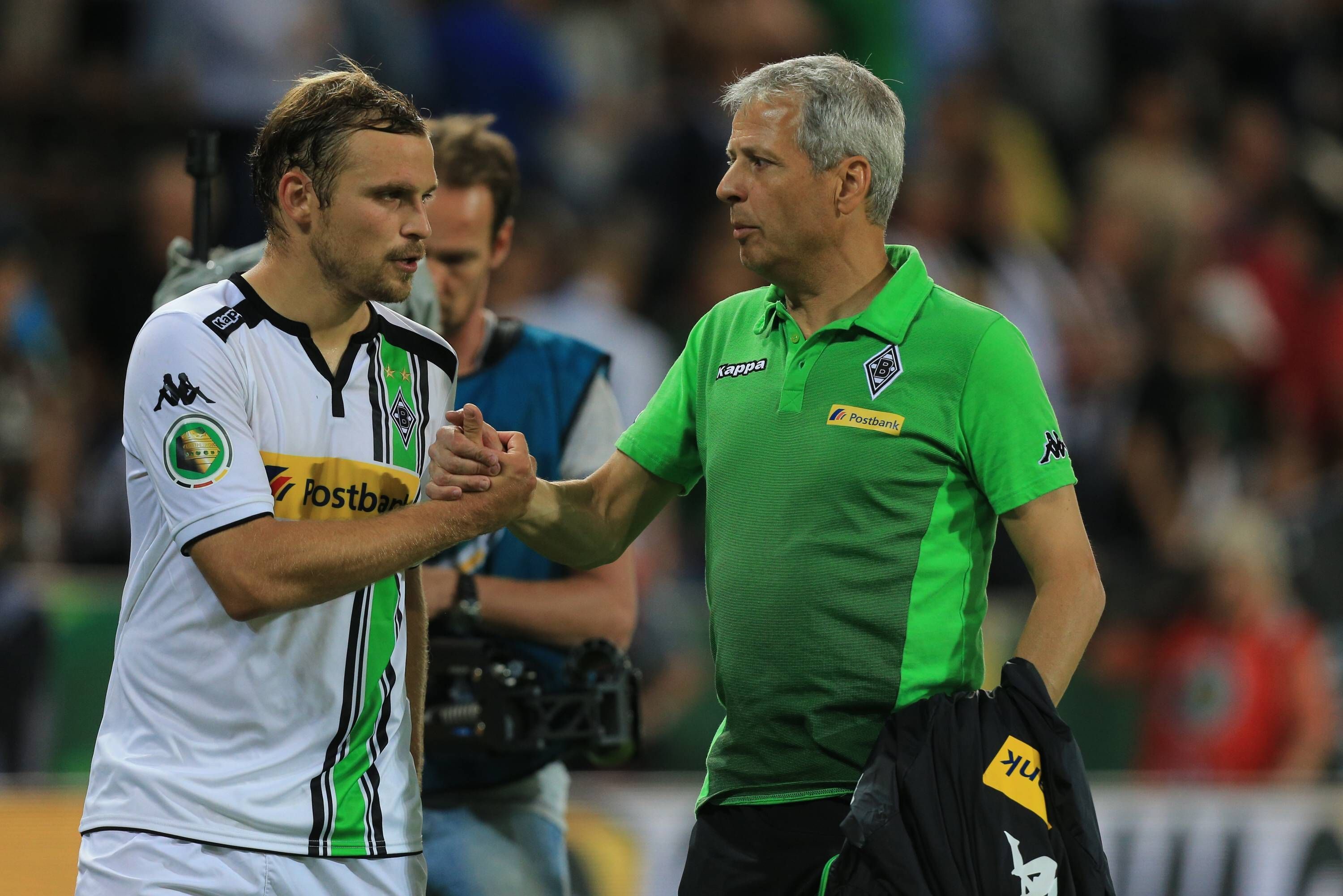 Der künftige Gladbach-Trainer Lucien Favre (r.) klatscht mit Borussia-Verteidiger Tony Jantschke (l.) ab. Dieses Foto stammt vom DFB-Pokalspiel der Fohlen-Elf beim FC St. Pauli im Millerntor-Stadion am 10. August 2015. Beide blicken noch angespannt drein.