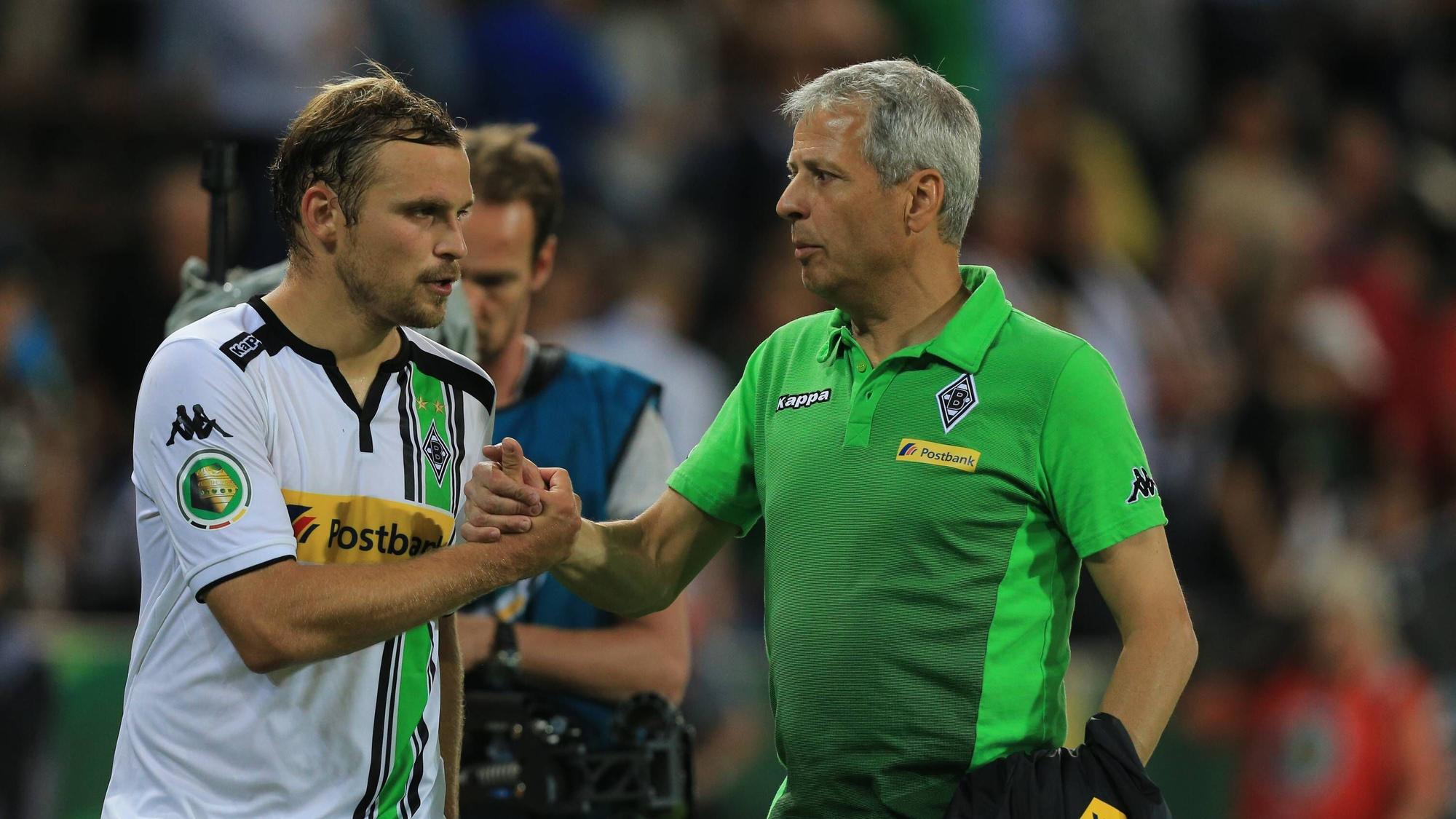 Der künftige Gladbach-Trainer Lucien Favre (r.) klatscht mit Borussia-Verteidiger Tony Jantschke (l.) ab. Dieses Foto stammt vom DFB-Pokalspiel der Fohlen-Elf beim FC St. Pauli im Millerntor-Stadion am 10. August 2015. Beide blicken noch angespannt drein.