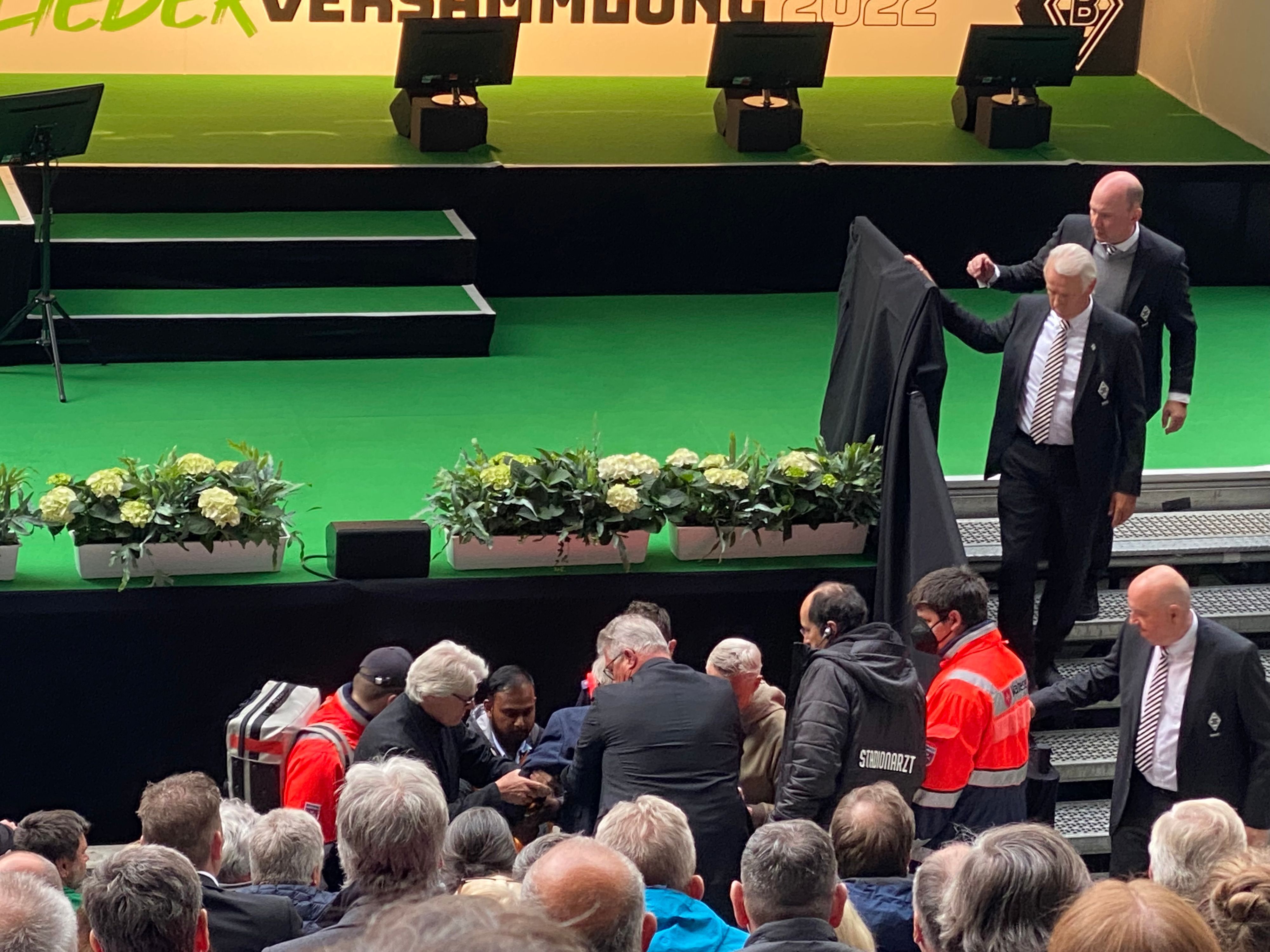 Medizinischer Notfall bei der Mitgliederversammlung von Borussia Mönchengladbach am 30. Mai 2022. Stadionsprecher-Legende Rolf Göttel ist zusammengebrochen. Es eilen zahlreiche Helfer zur Stelle.